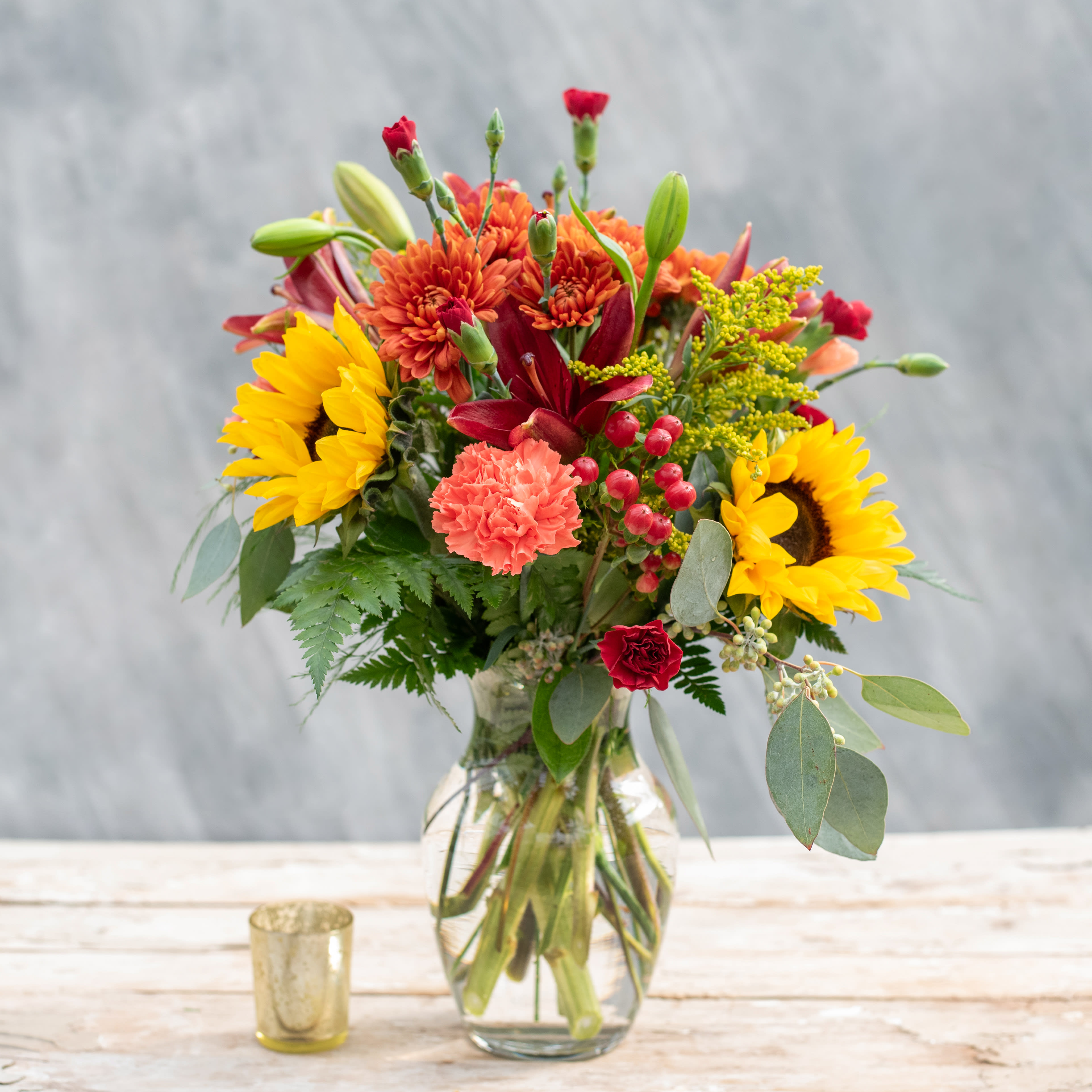 Cambridge - A beautiful autumnal mix including sunflowers, lilies, mums, carnations accented with hypericum berries and premium greens.