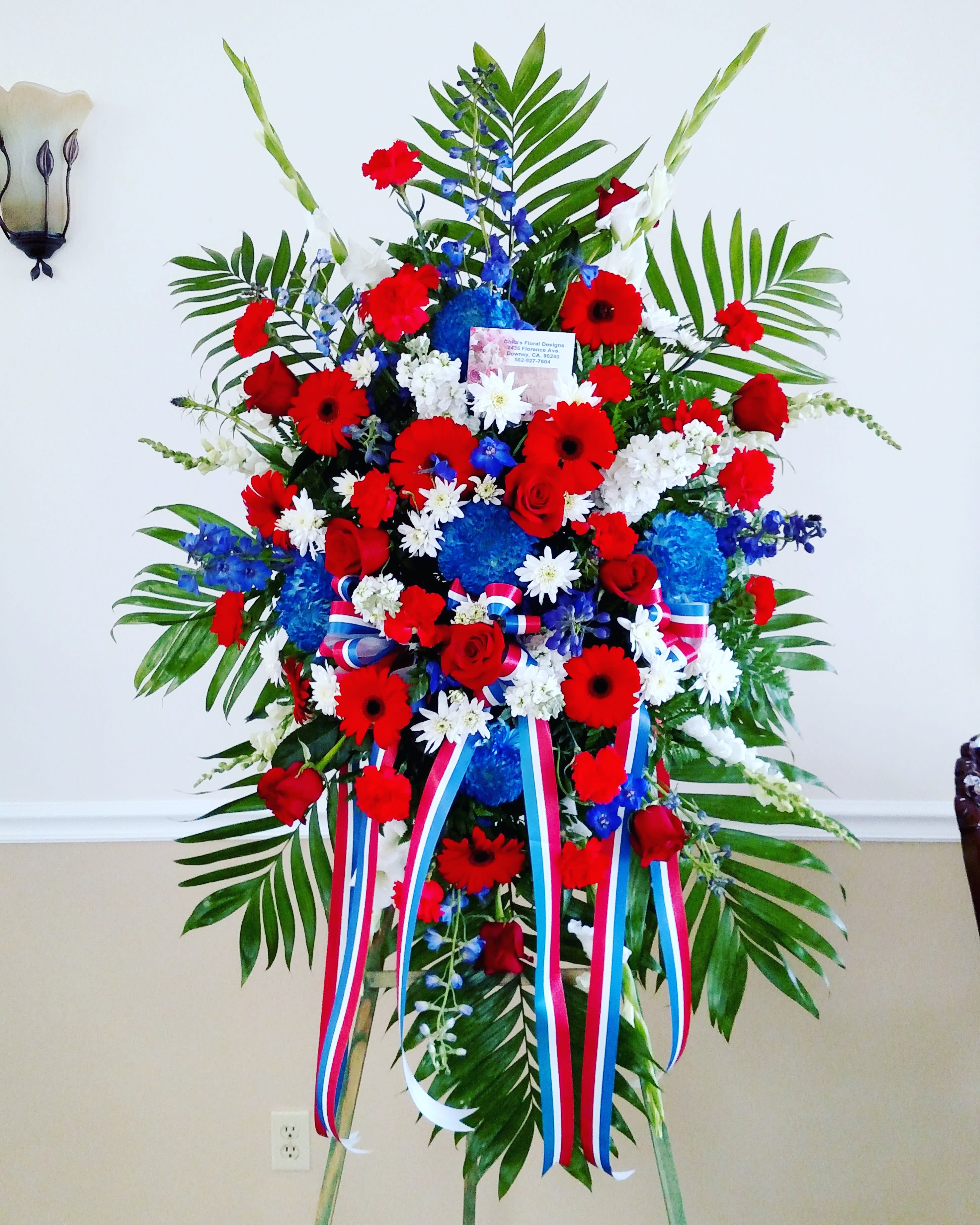 Large standing floral spray with red, white, and blue flowers