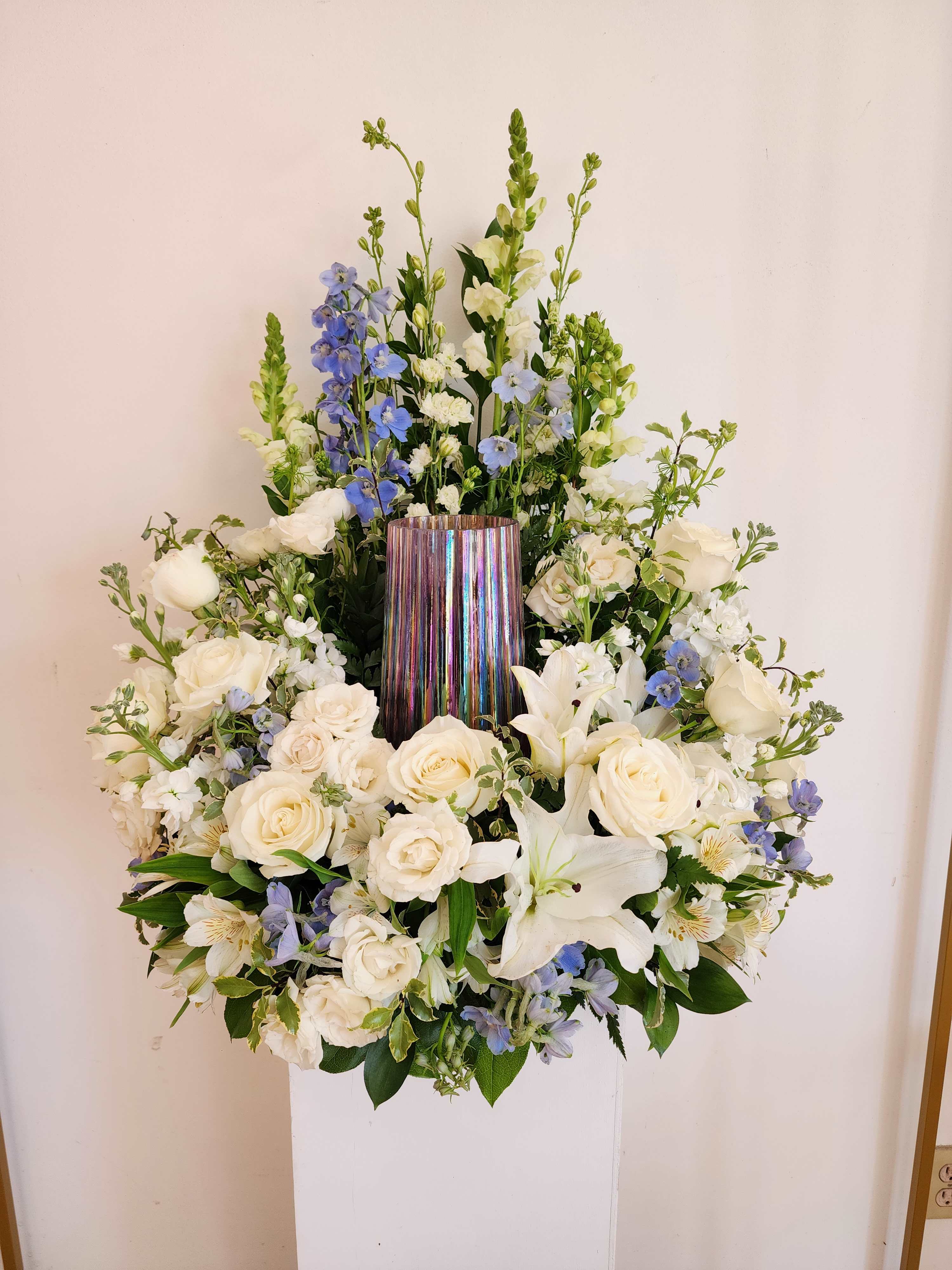White and blue floral arrangement in a metallic vase
