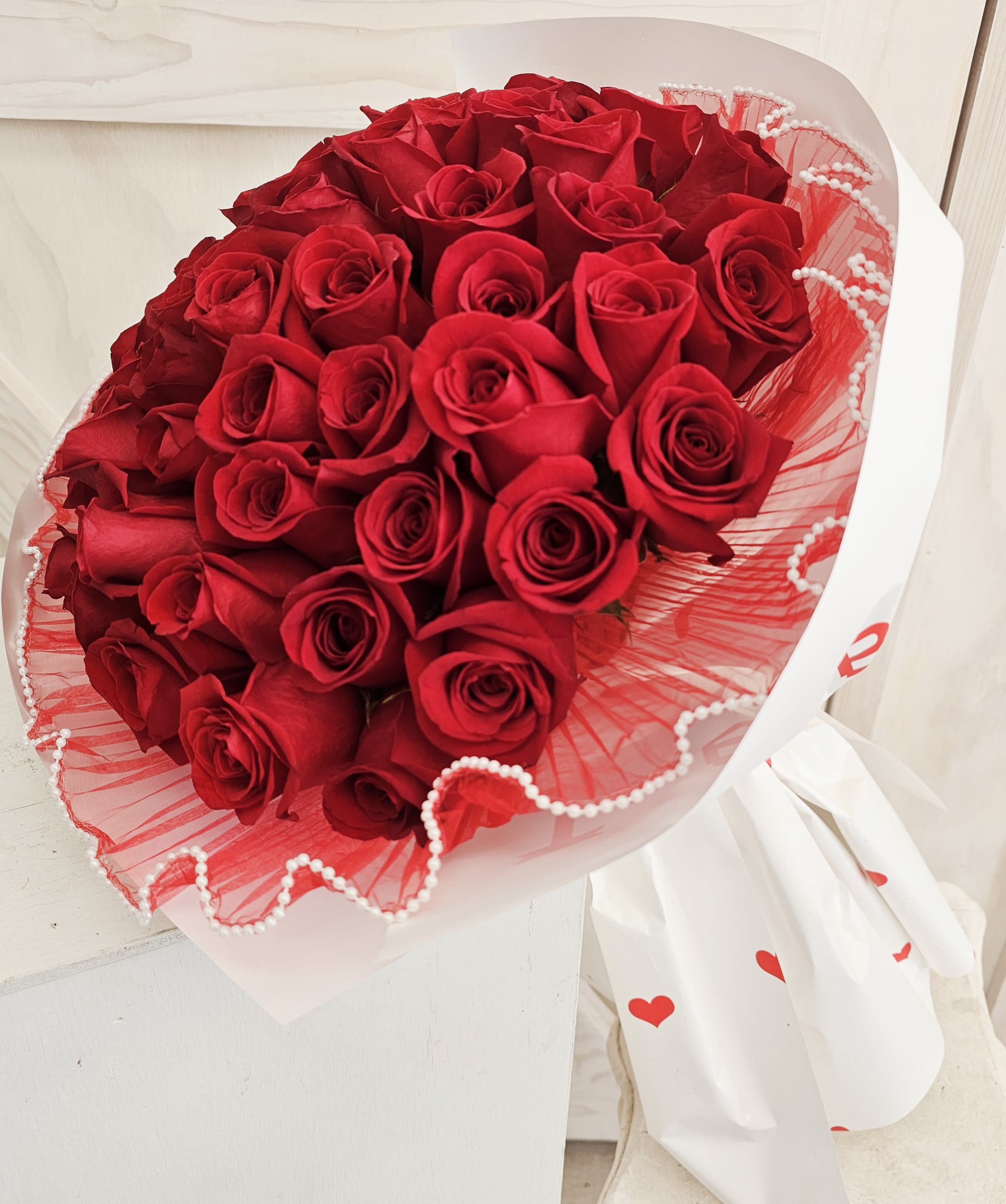 Bouquet of red roses wrapped in white and red paper