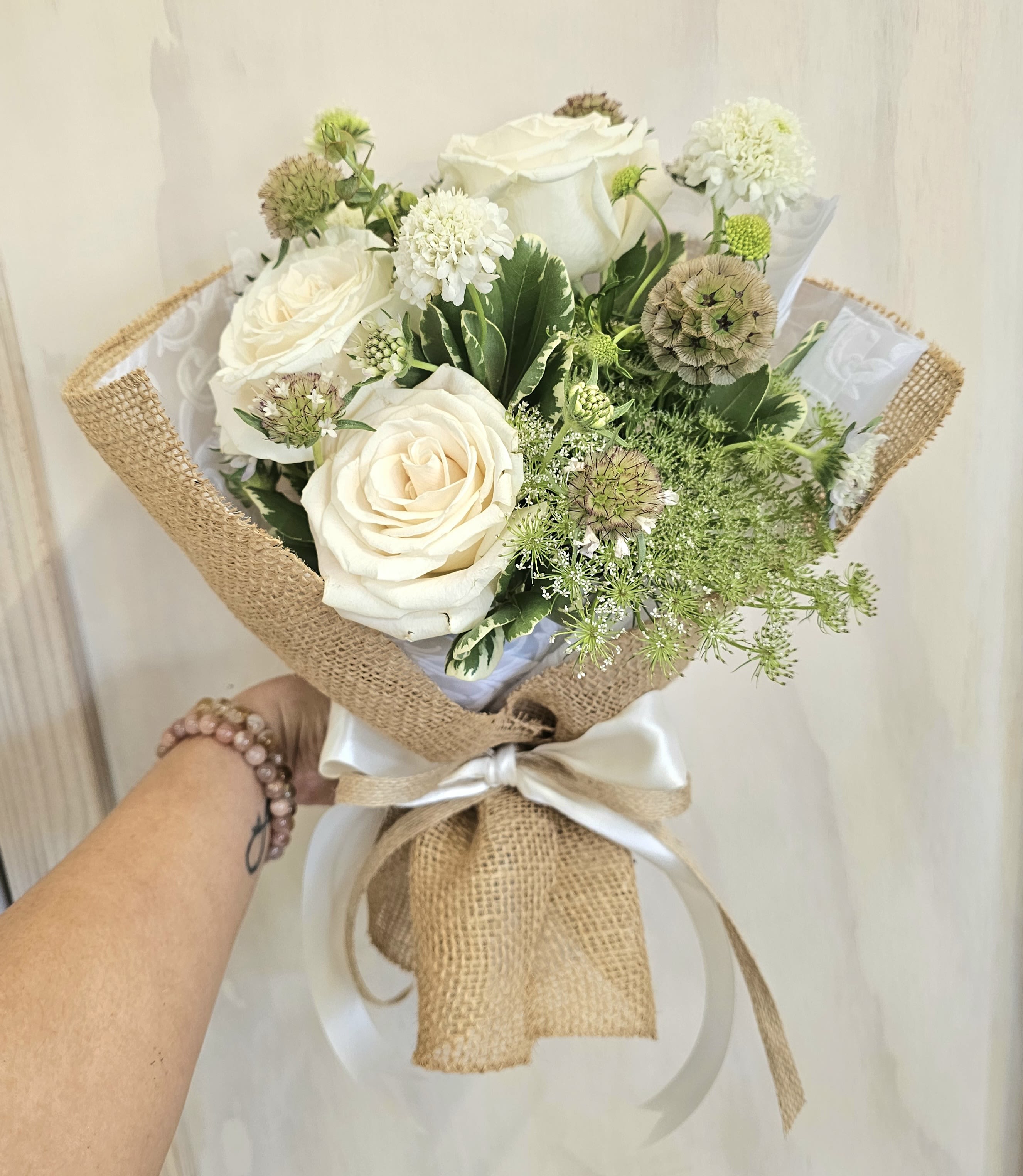 White rose bouquet wrapped in burlap with a satin ribbon