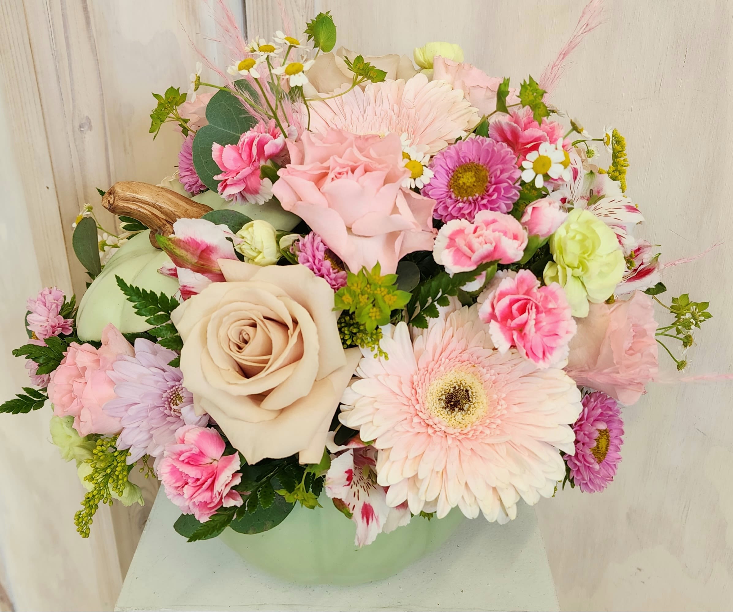 Pastel mixed flower arrangement in a pale green vase