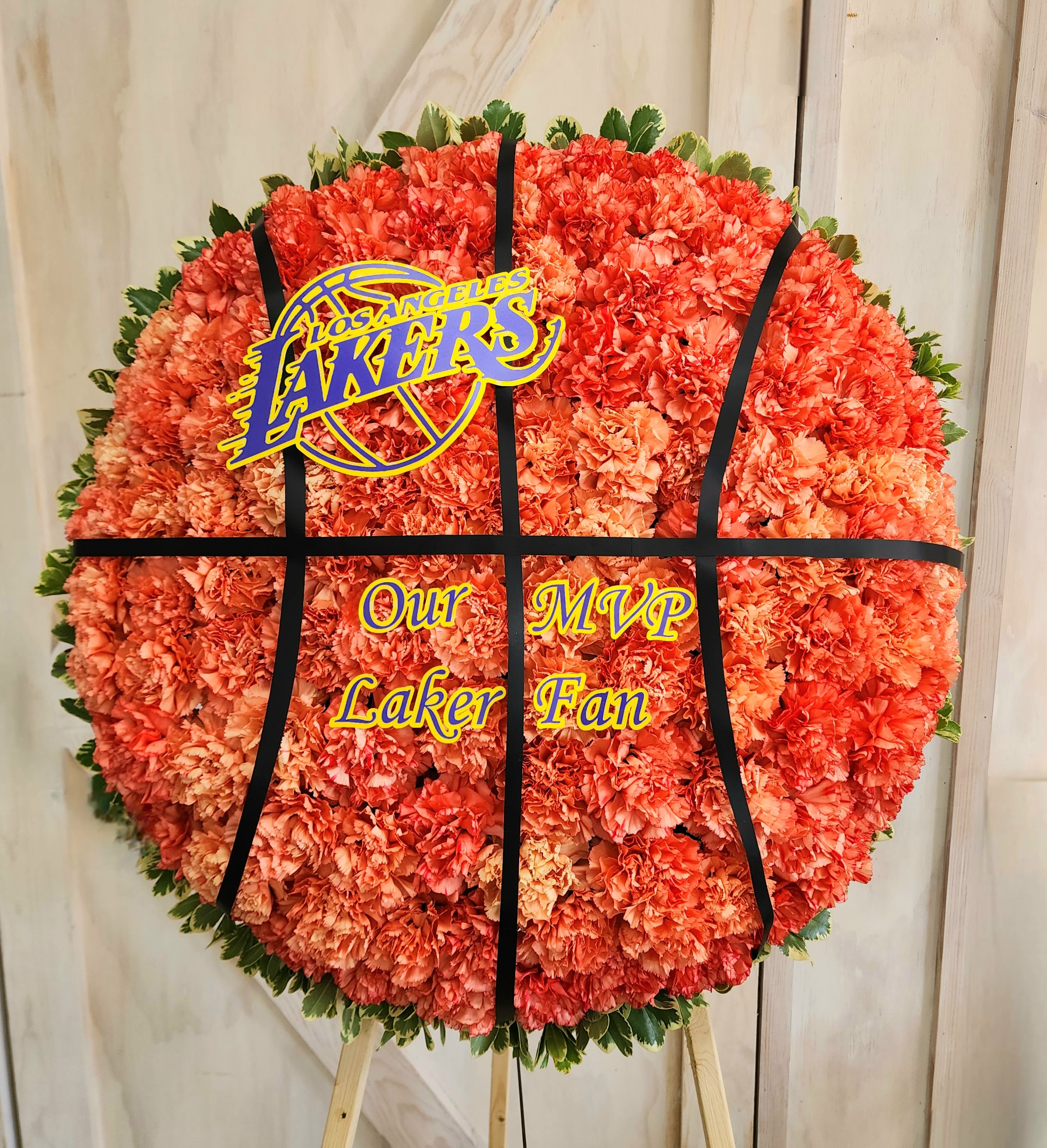 Round orange carnation tribute with a Los Angeles Lakers sign