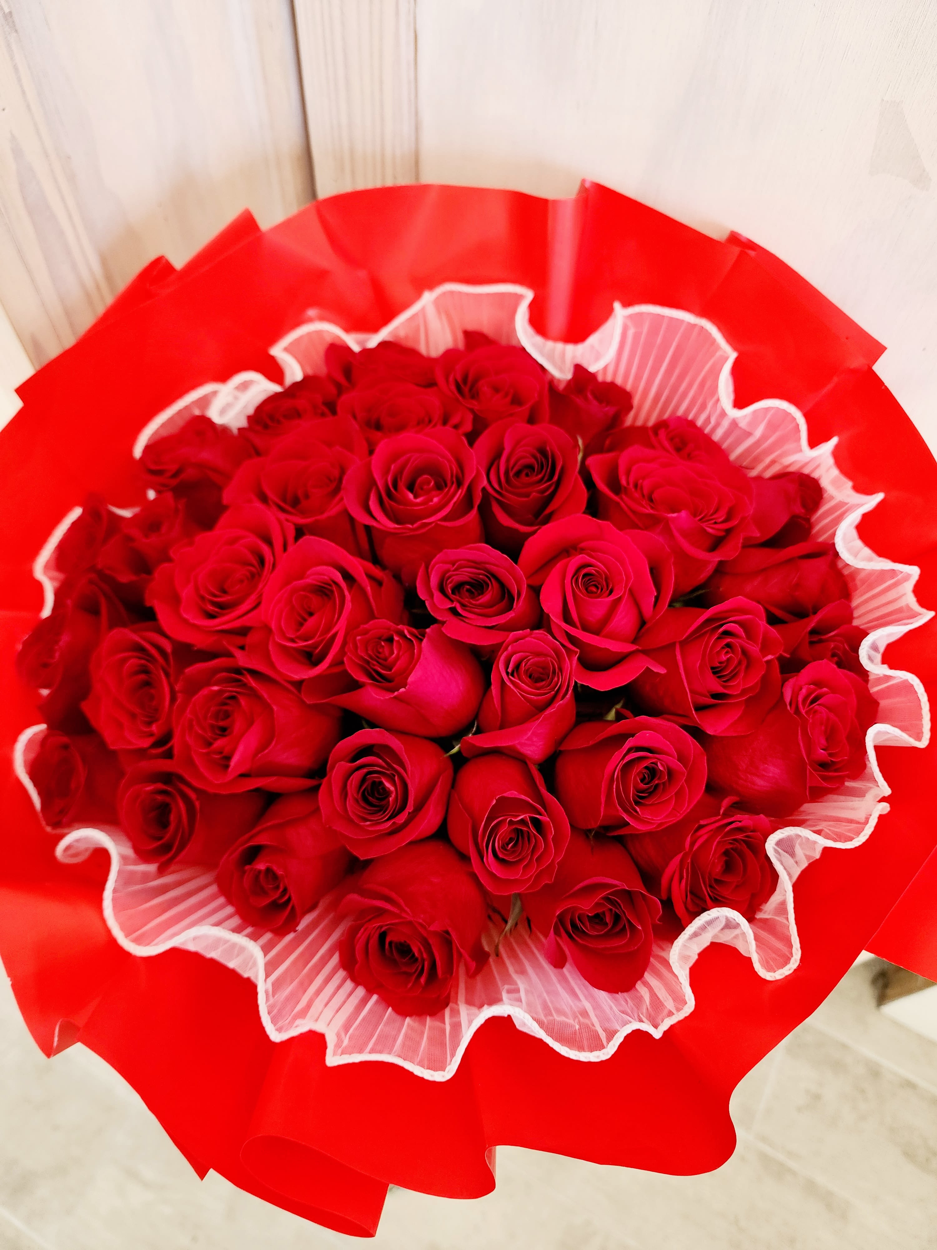 Bouquet of red roses wrapped in bright red paper