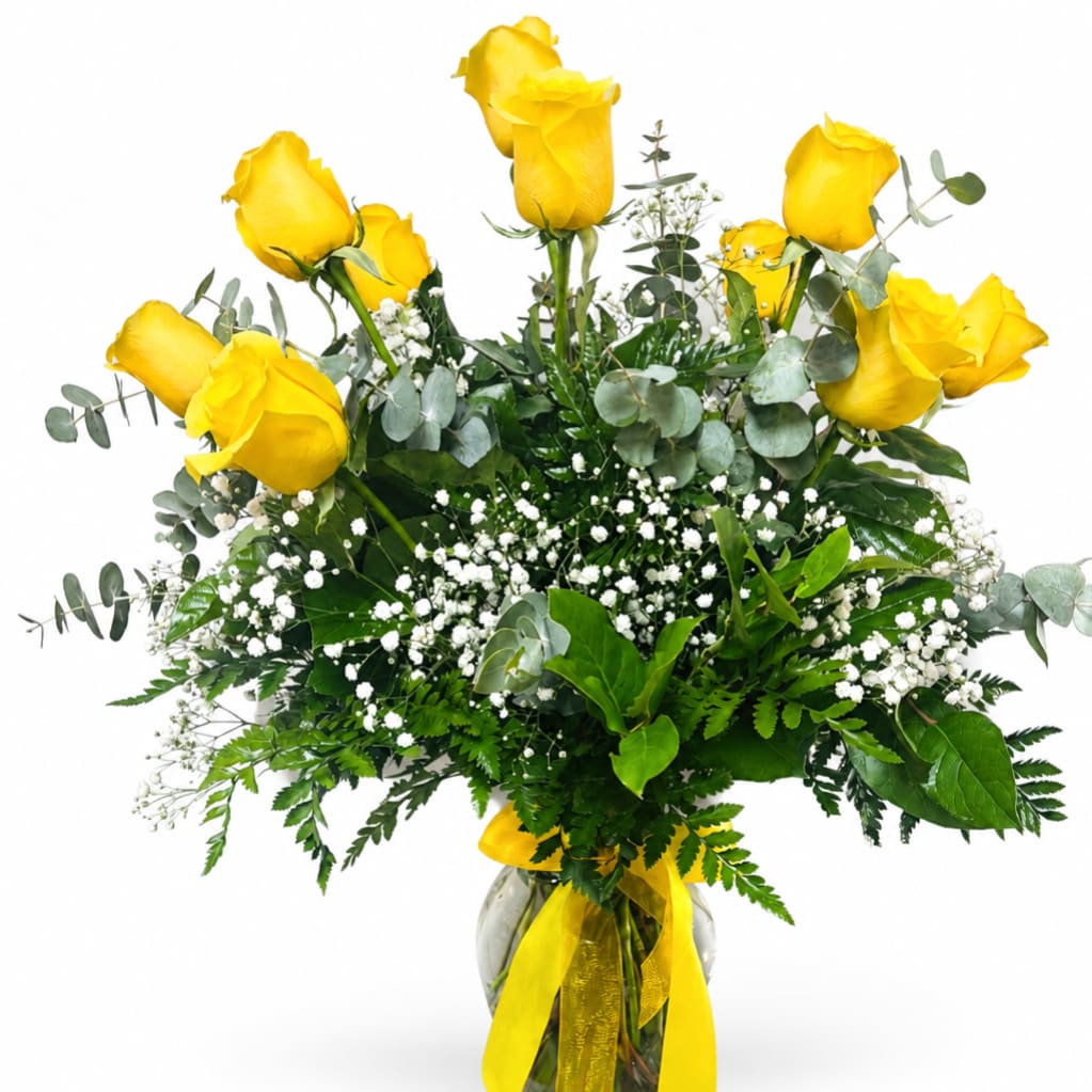 Yellow roses arranged in a glass vase with white filler flowers