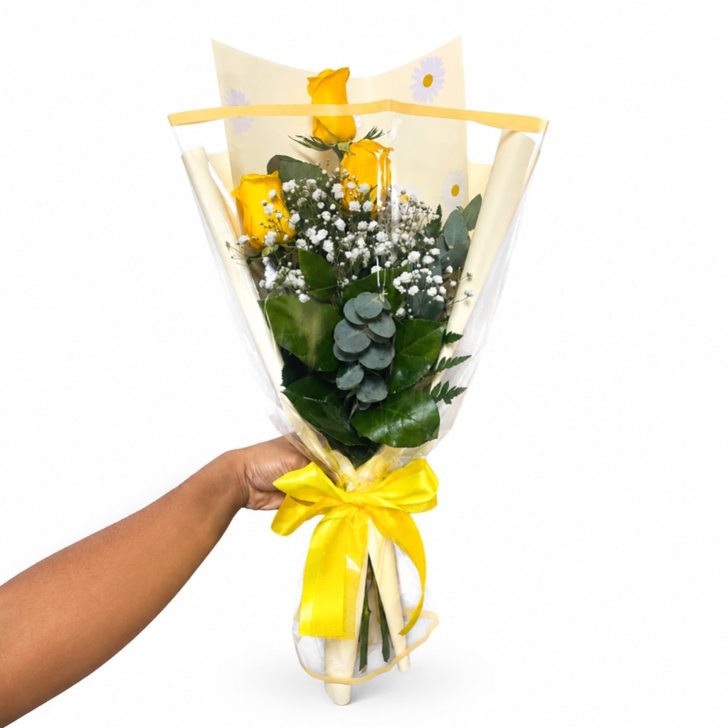 Handheld bouquet of yellow roses with baby's breath wrapped in clear plastic