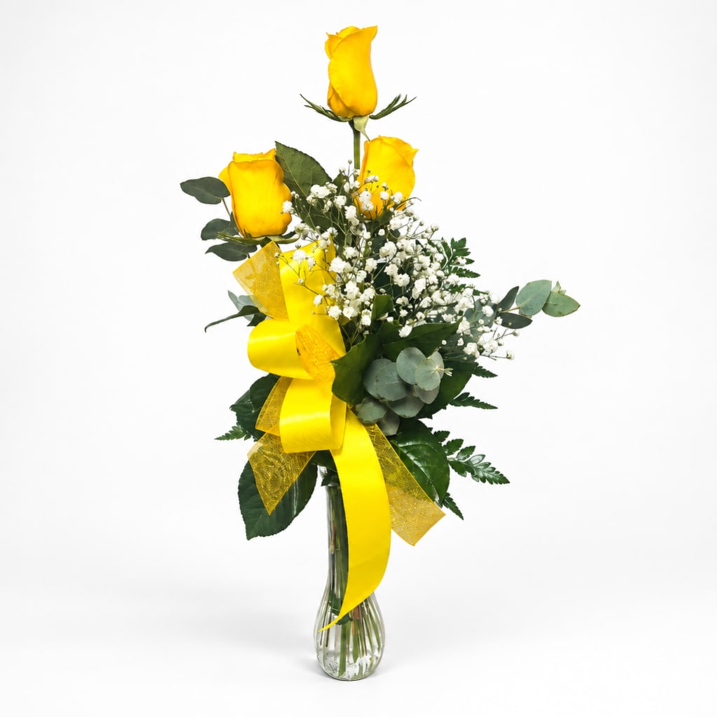 Yellow roses in a clear glass vase with baby's breath and a yellow ribbon