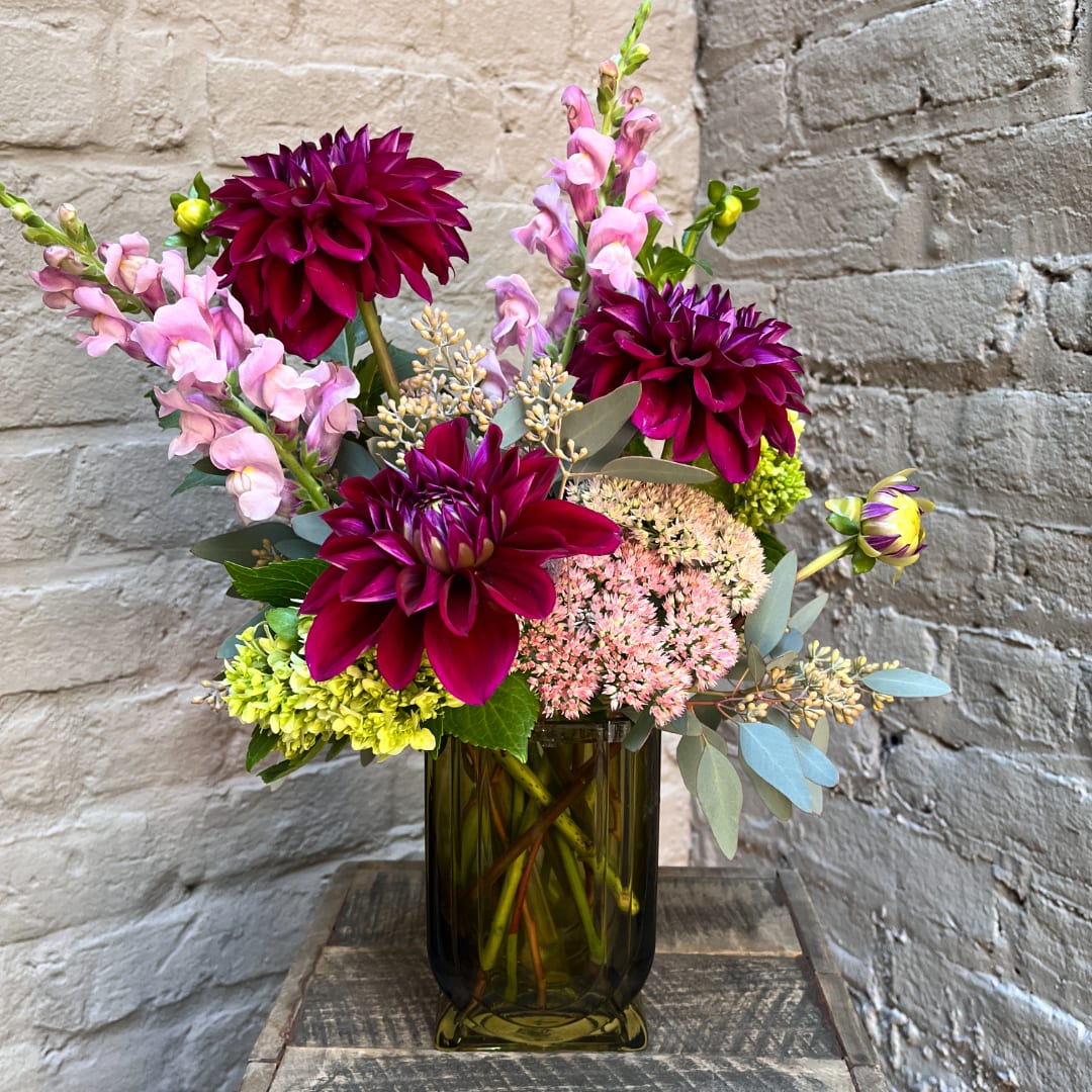 Bouquet of magenta dahlias and pink snapdragons in a glass vase