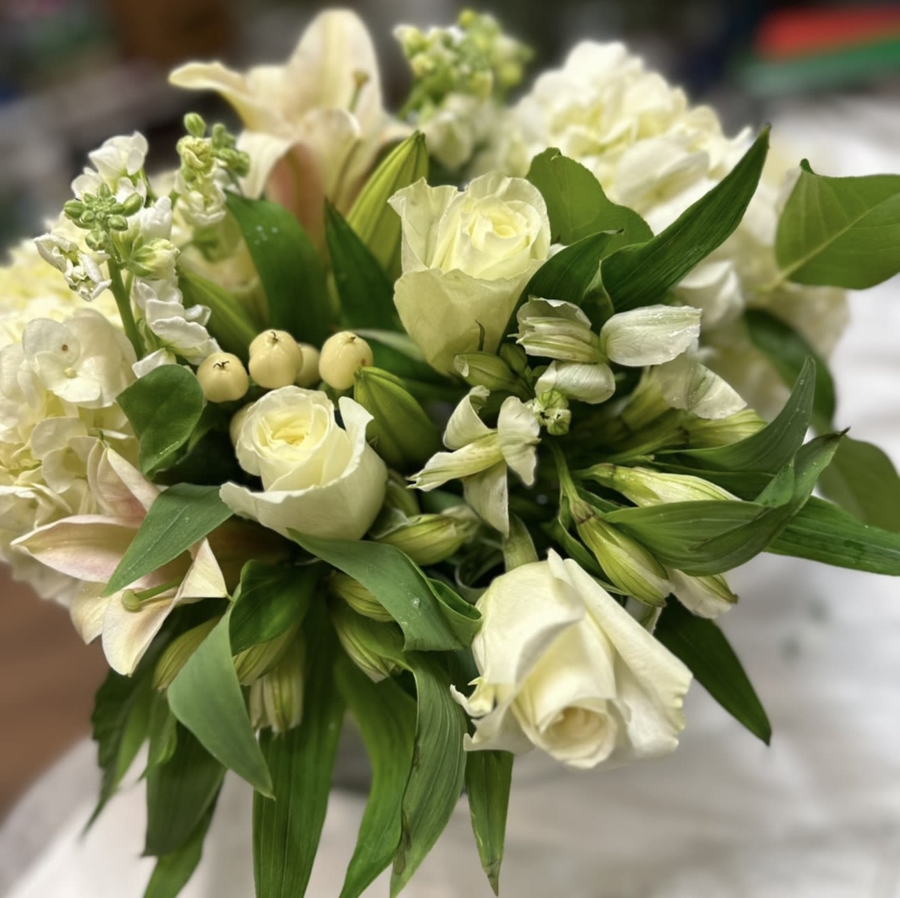 WHITE AND GREEN PRAYERS - WHITE ROSES WHITE ALSTROMERIA WHITE BERRIES WITH GREENERY IN A CUBE