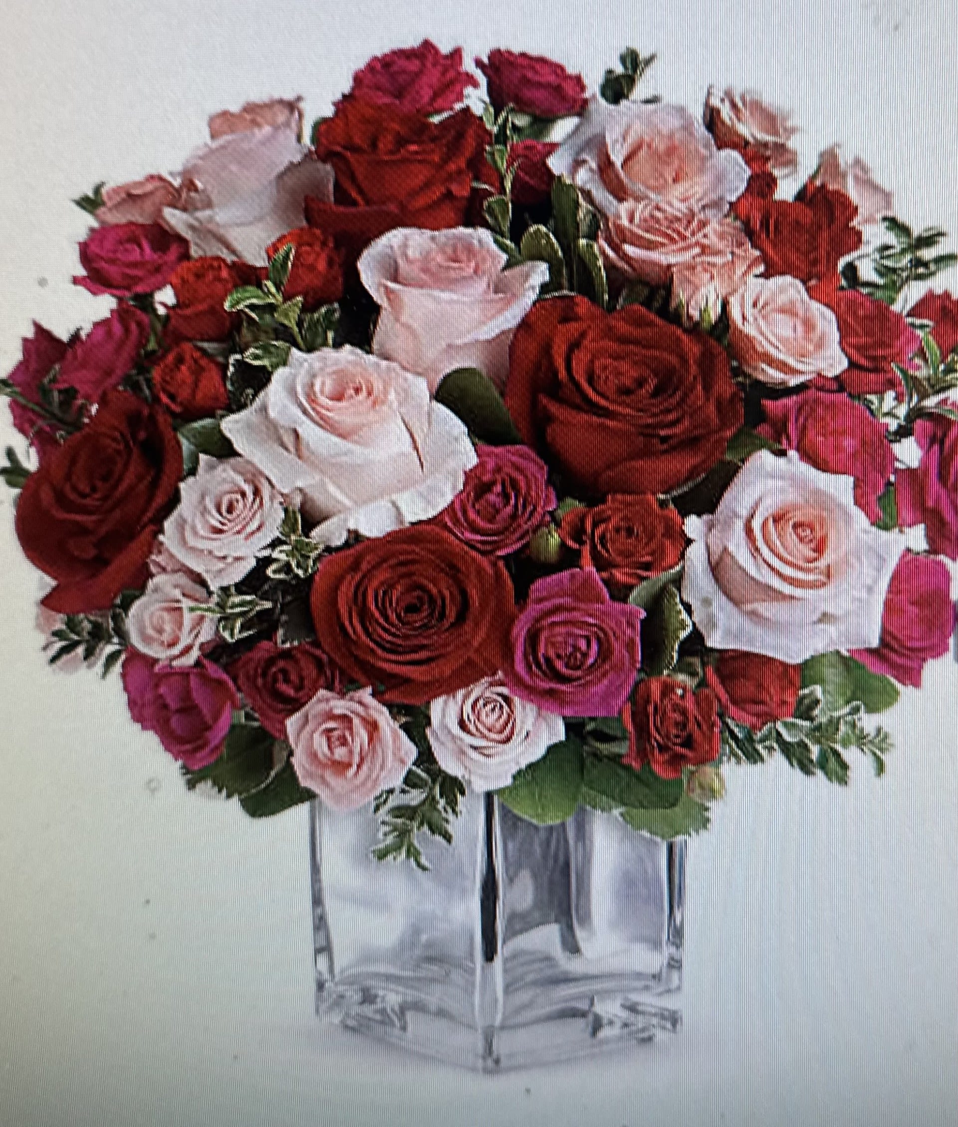 BED OF ROSES BOUQUET - BEAUTIFUL BED OF STANDARD ROSES WITH SPRAY ROSES WITH GREENS IN A CLEAR GLASS CUBE. 