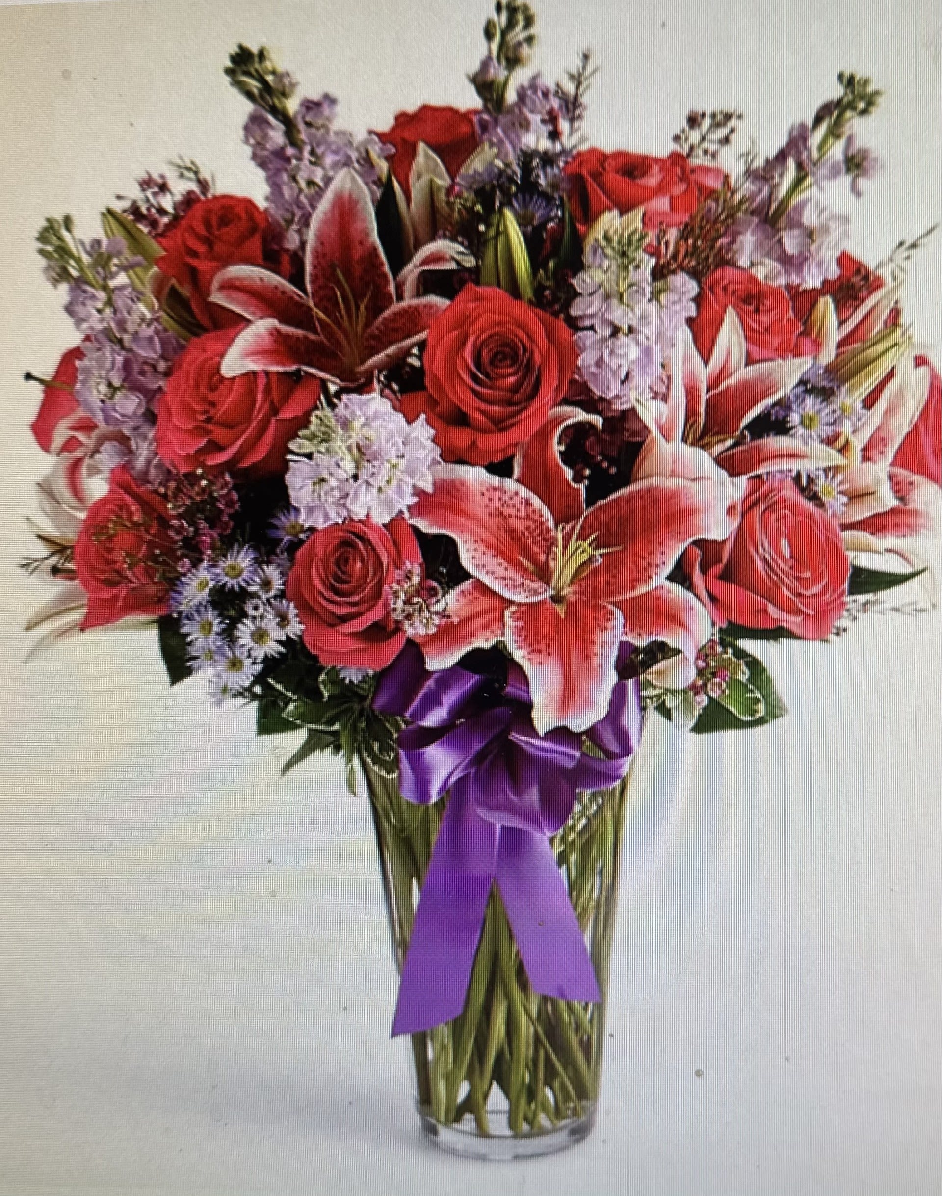 STARGAZING BOUQUET - STUNNING BOUQUET OF STARGAZER LILIES, RED ROSES, STOCK, ASTERS, IN A PURPLE RIBBONED VASE. STATEMENT ARRANGEMENT.