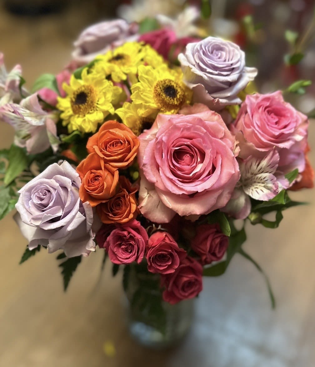 RADIANT RAINBOW BOUQUET - SCRUMPTIOUS BOUQUET OF RAINBOW COLORS BRIGHT AND BEAUTIFUL!!! PINK AND LAVENDER ROSES, HOT PINK AND ORANGE SPRAY ROSES, YELLOW MUMS AND HOT AND LIGHT PINK ALSTROMERIA.  
