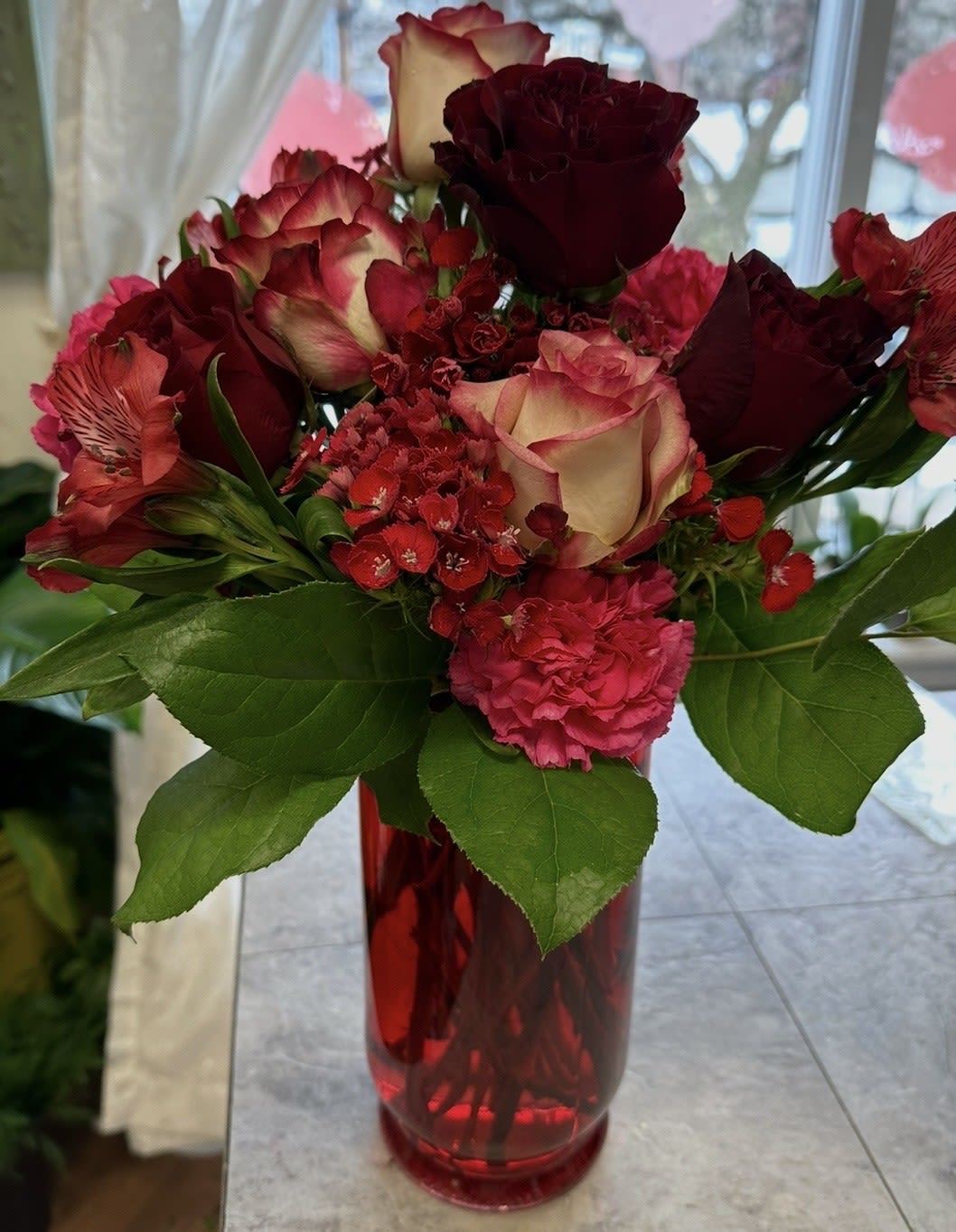 X'S AND O'S BOUQUET - BEATIFUL MIX OF LIGHT AND DARK FLOWERS!! BICOLOR ROSES, RED ROSES, RED BERRIES, SWEET WILLIAM AND ALSTROMERIA IN A RED VASE. SWEET LOVE!!
