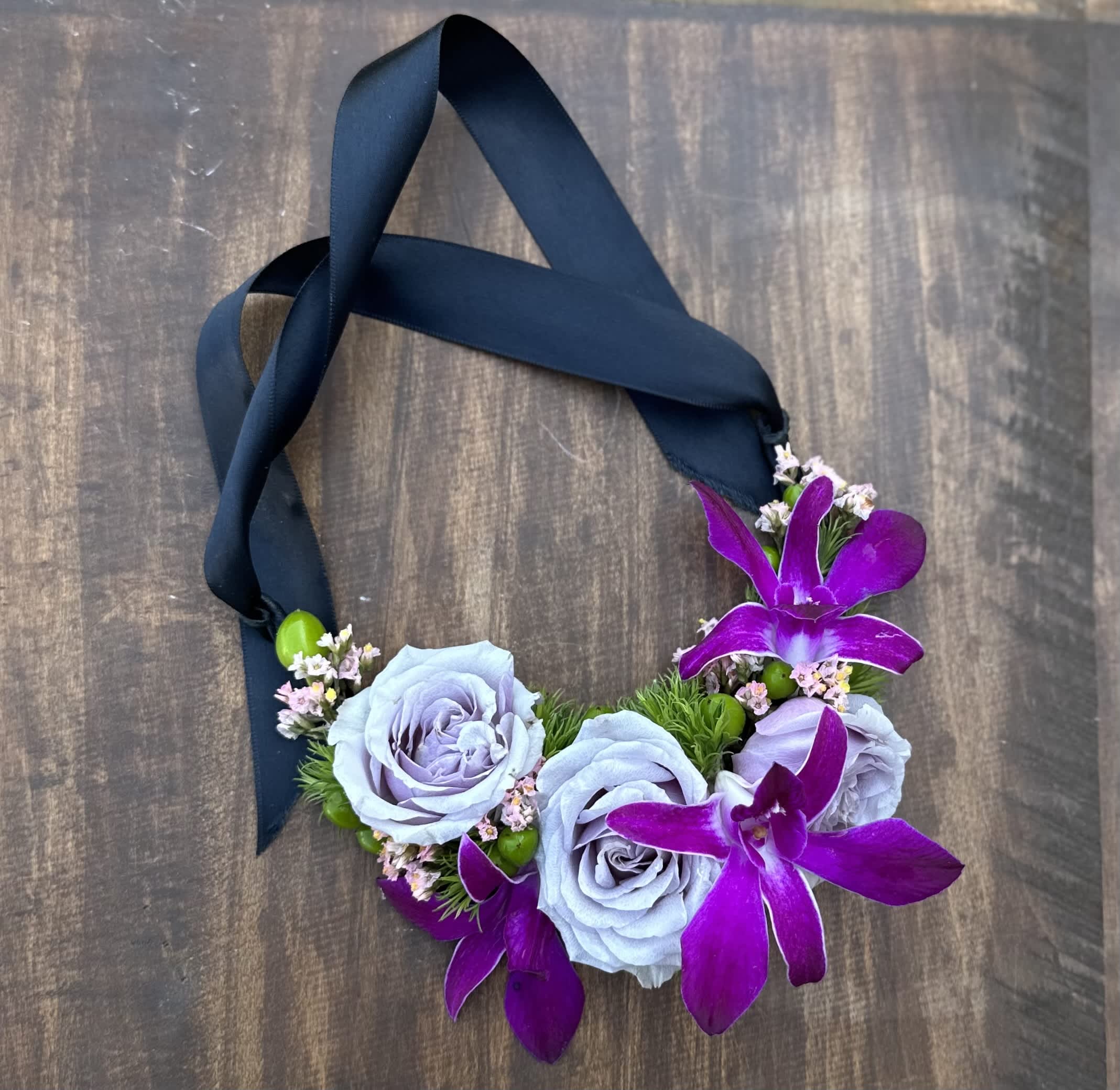 Floral necklace with lavender roses and purple orchids on a dark ribbon