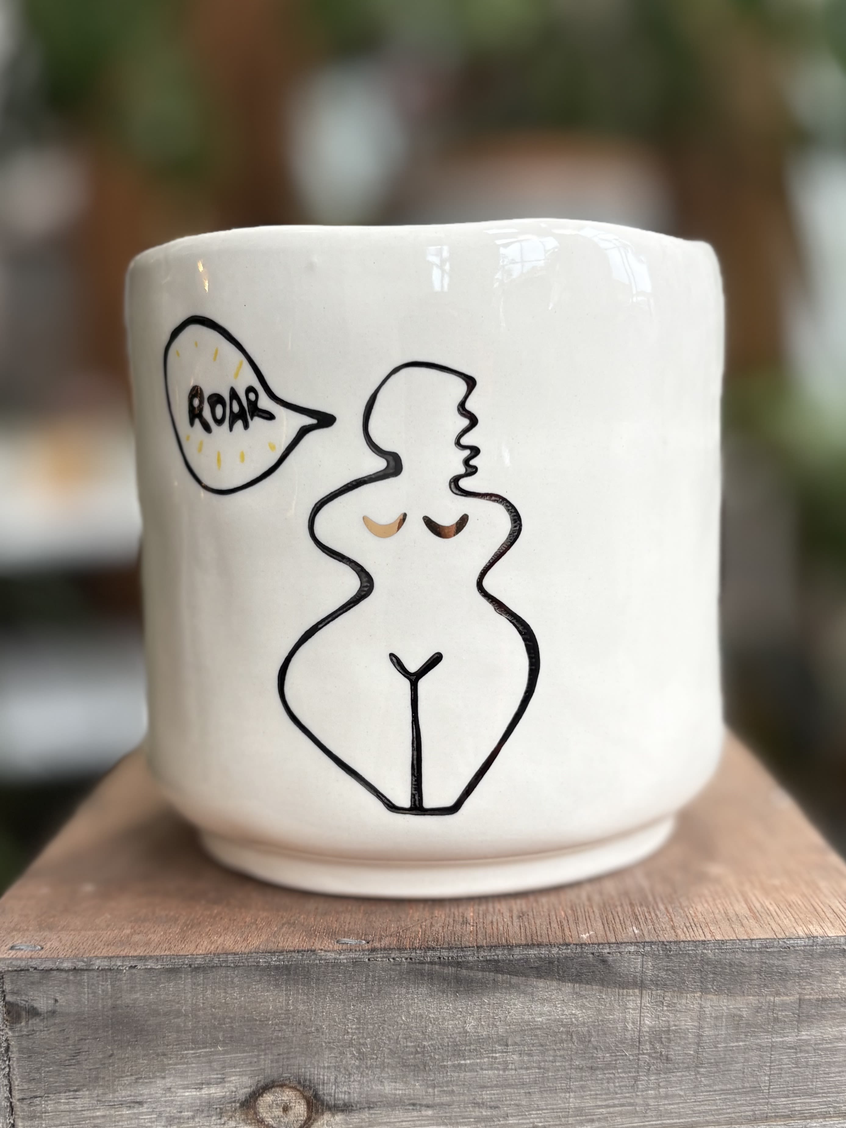 White ceramic mug with a line drawing of a nude figure and a speech bubble