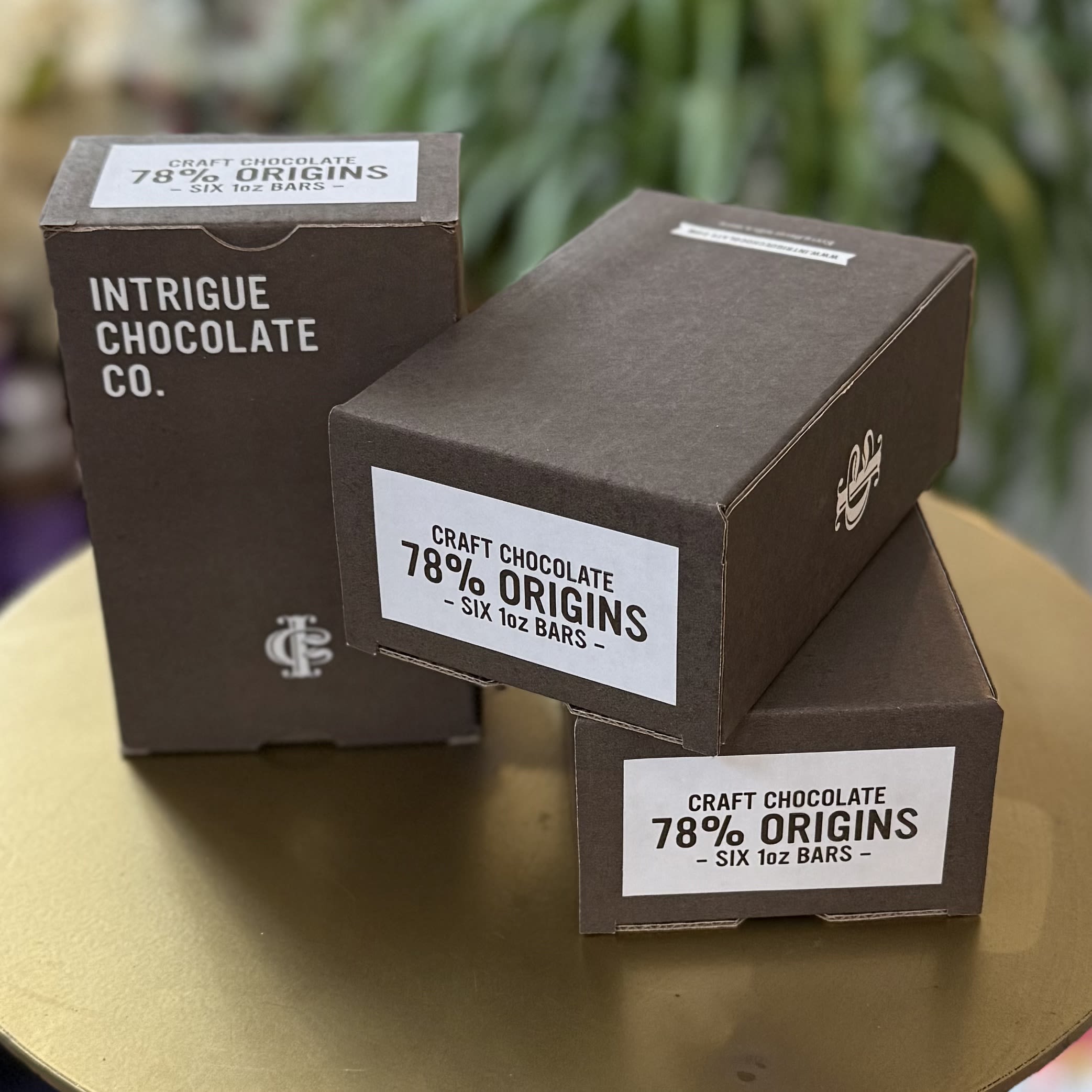 Intrigue Chocolate Co Origins 78% Cacao Chocolate Box - Six 1oz bars of 78% cacao chocolate from different locations around the globe. This box includes chocolate from Colombia, Ecuador, Ghana, Peru, Uganda, and Tanzania, and a chocolate tasting guide to ensure the tastiest journey for your tastebuds. Bon Voyage!