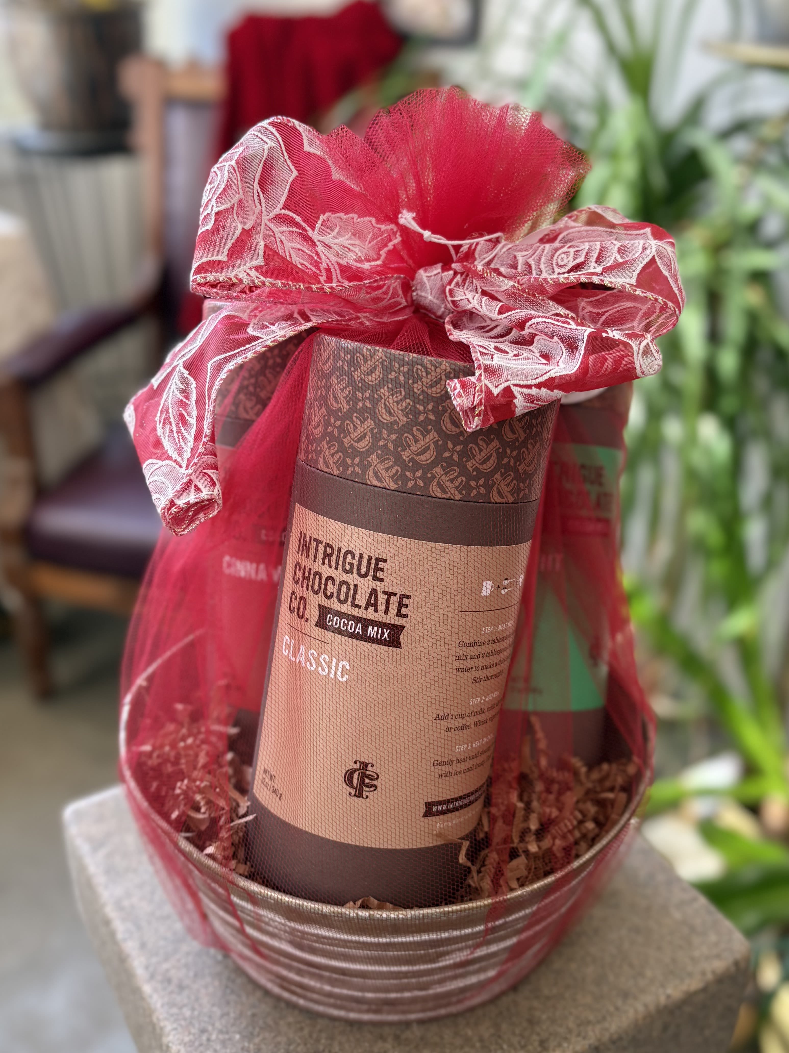Gift basket with a cocoa mix tin wrapped in red mesh ribbon