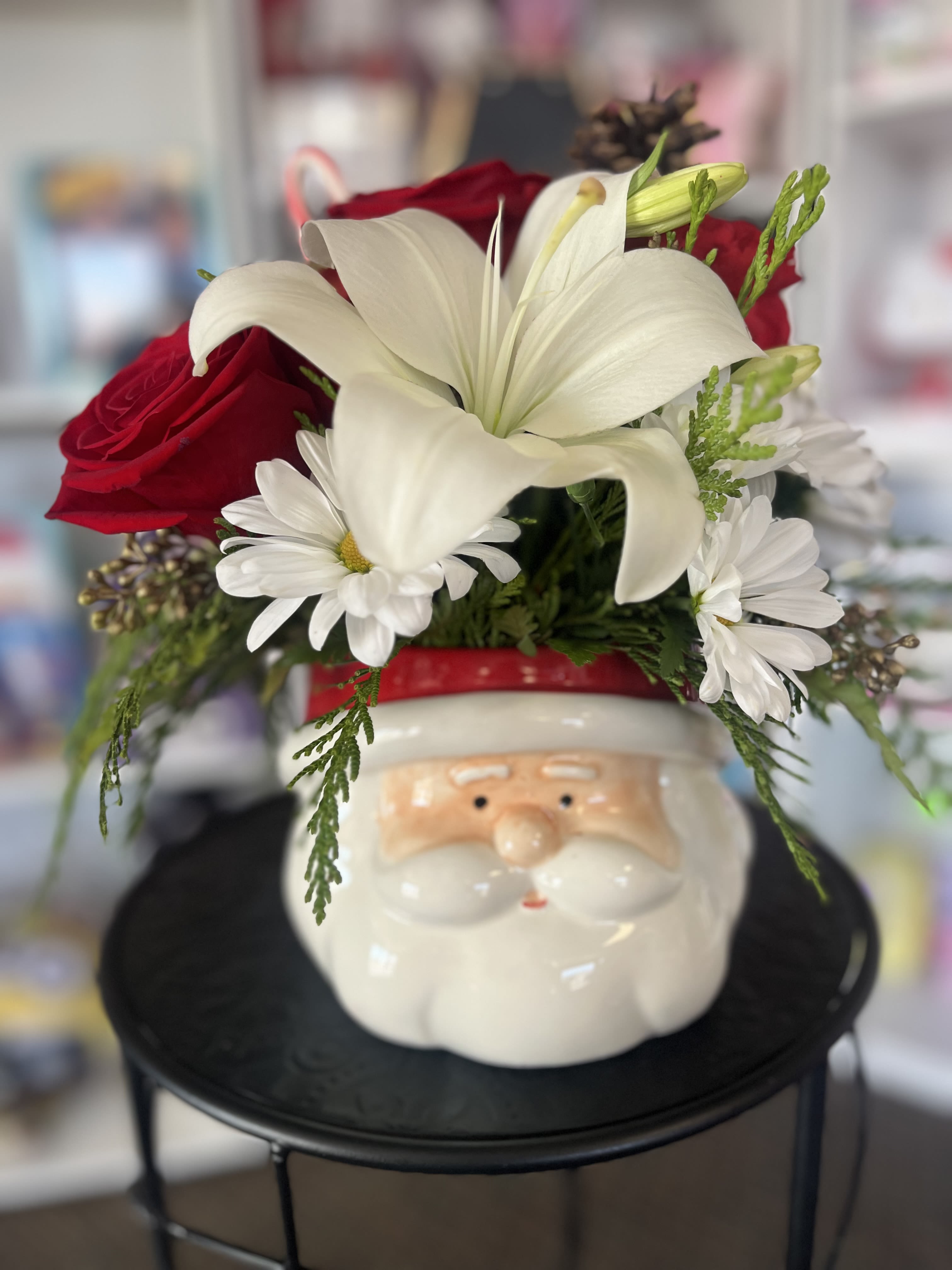 Red roses and white lilies arranged in a Santa face container