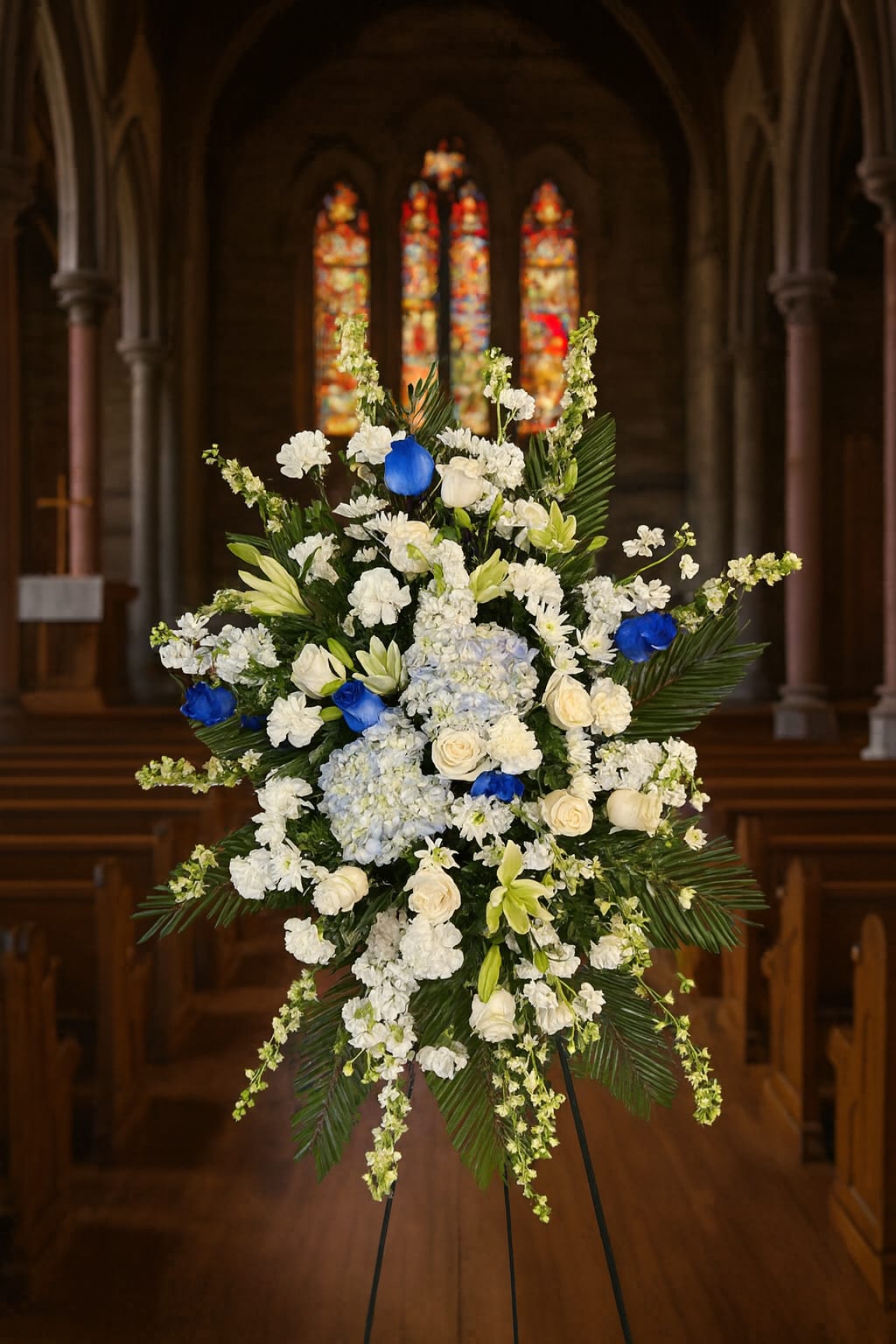 Large white and blue floral standing spray in a church