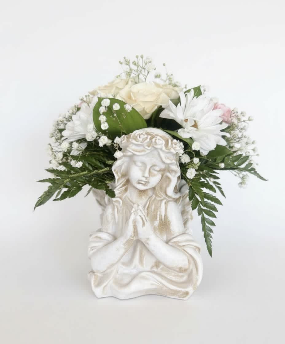 White floral arrangement in a decorative angel planter