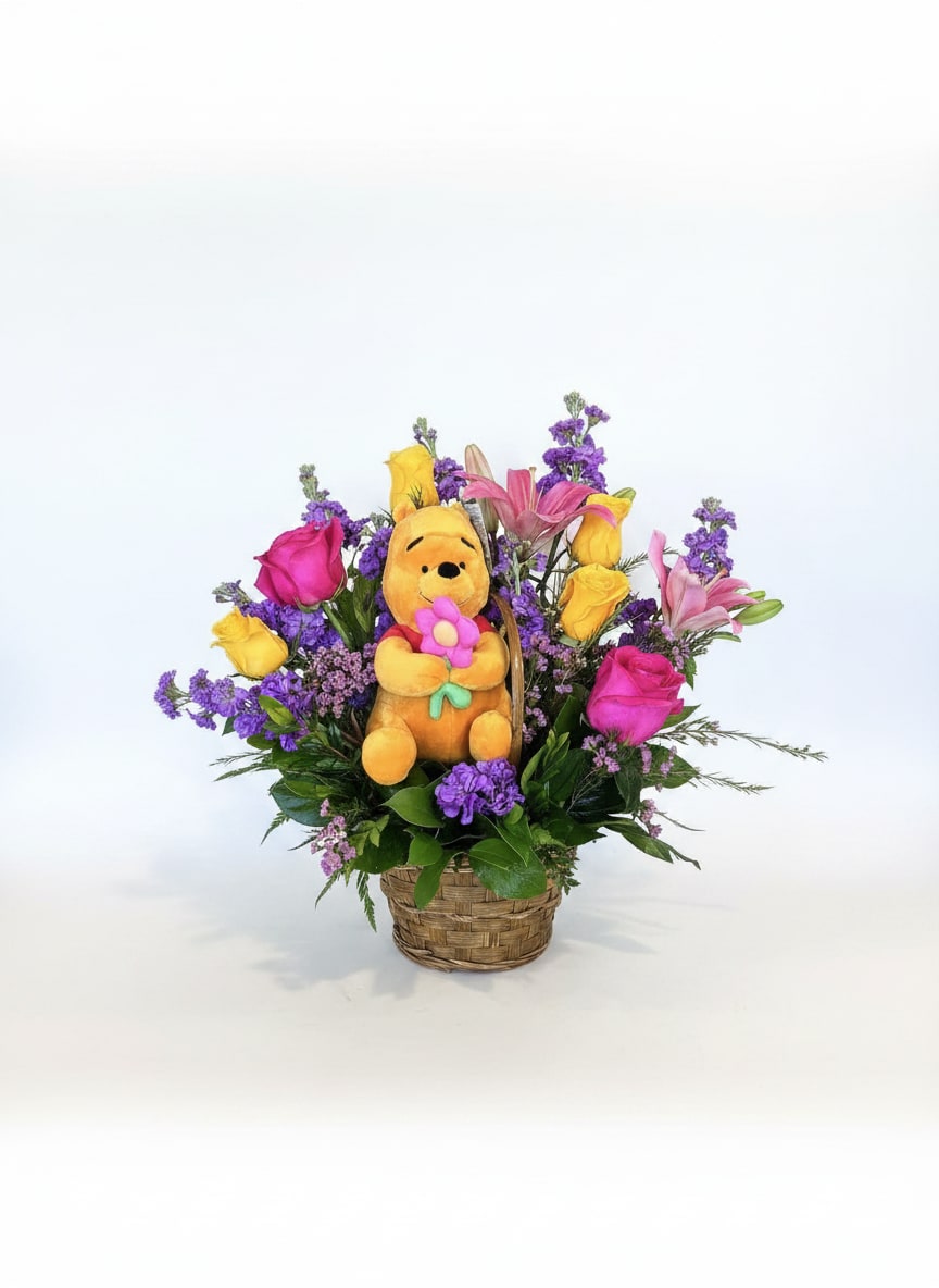 Basket arrangement with a plush Winnie the Pooh toy and colorful flowers