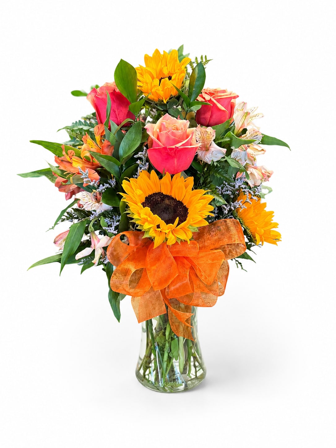 Mixed bouquet with sunflowers, roses, and alstroemeria in a glass vase