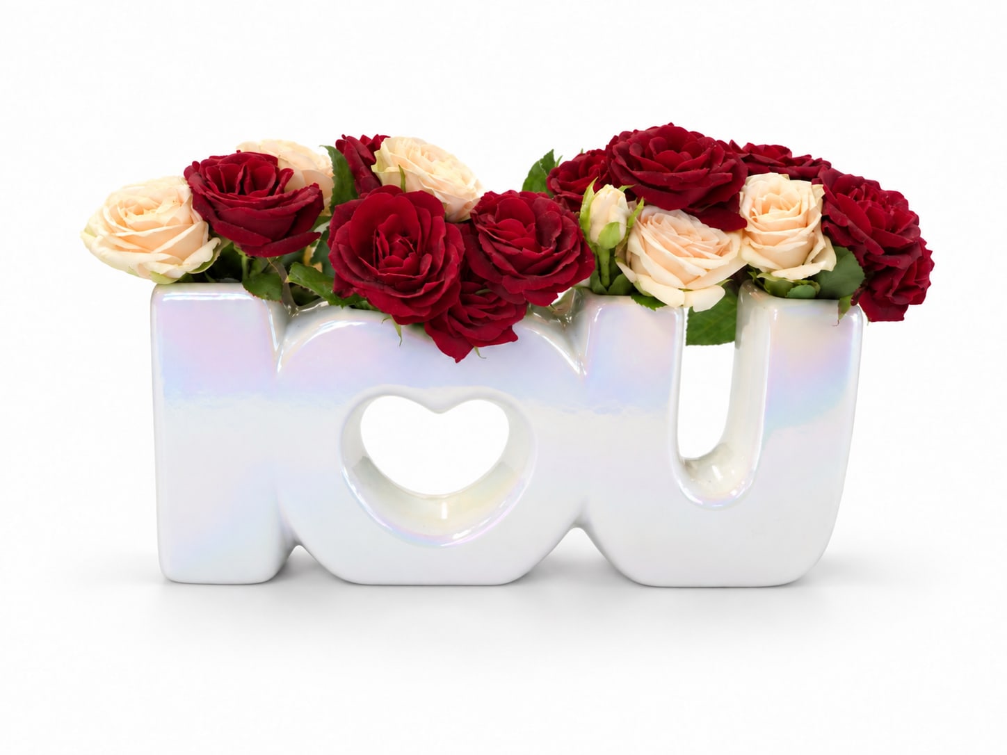 Red and cream roses arranged in a ceramic "love" vase