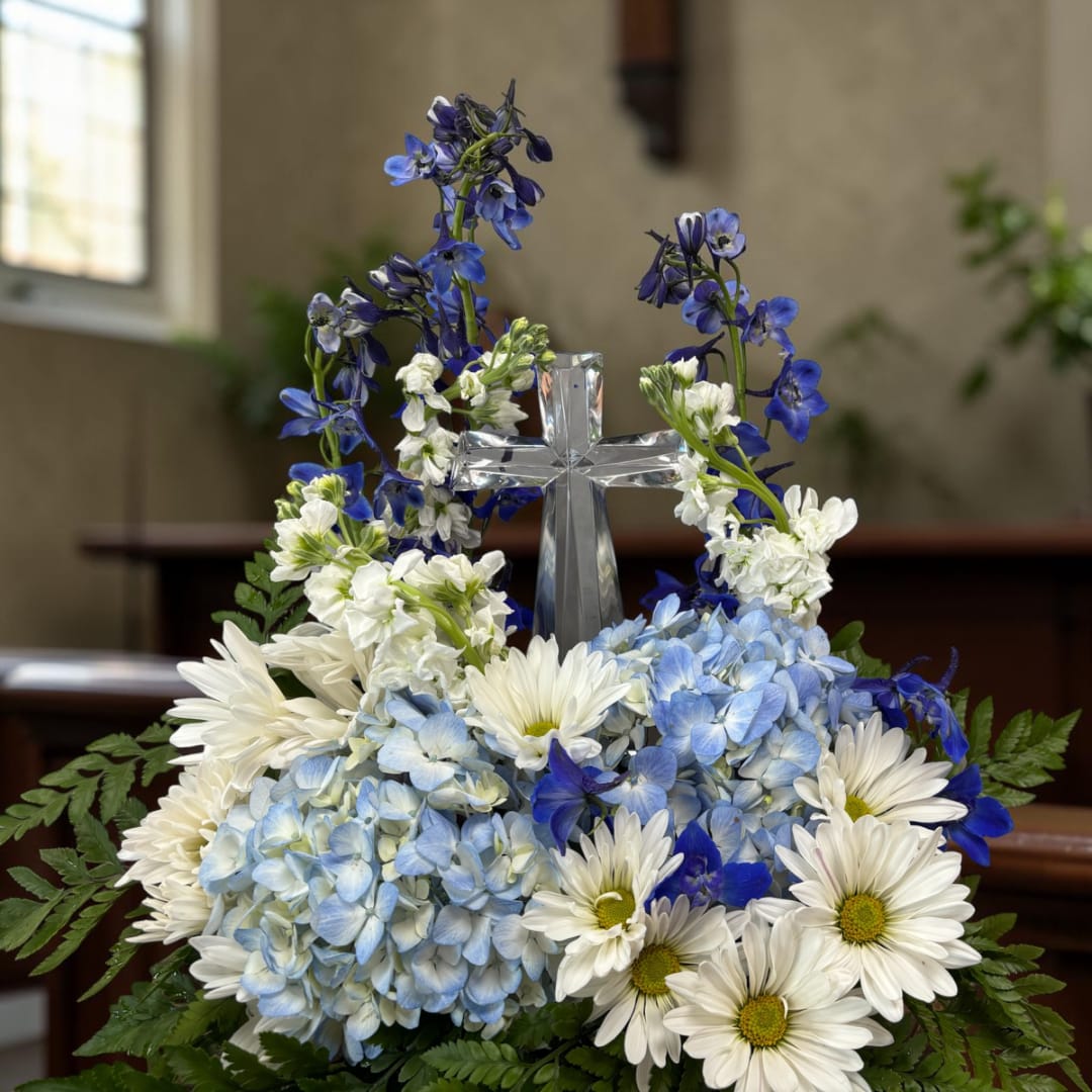 Blue and white floral arrangement with a clear cross centerpiece