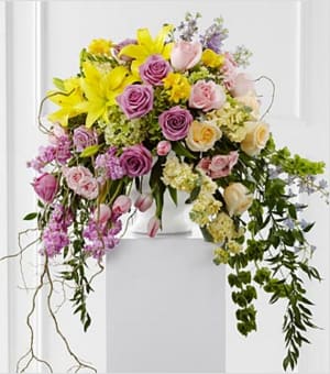 The FTD® Display of Affection™ Arrangement - The FTD® Display of Affection™ Arrangement is an exquisite way to commemorate the life of the deceased. Lavender roses, yellow stock, pink stock, pink tulips, yellow roses, pink roses, pink spray roses, lavender larkspur, Bells of Ireland, yellow freesia, yellow Asiatic lilies, blue delphinium, green hydrangea and lush greens are accented with curly willow branches and arranged to create a sophisticated display that radiates elegance and grace at their final farewell service. GOOD arrangement includes 54 stems, Approximately 36"H x 24"W. Your purchase includes a complimentary personalized gift message.