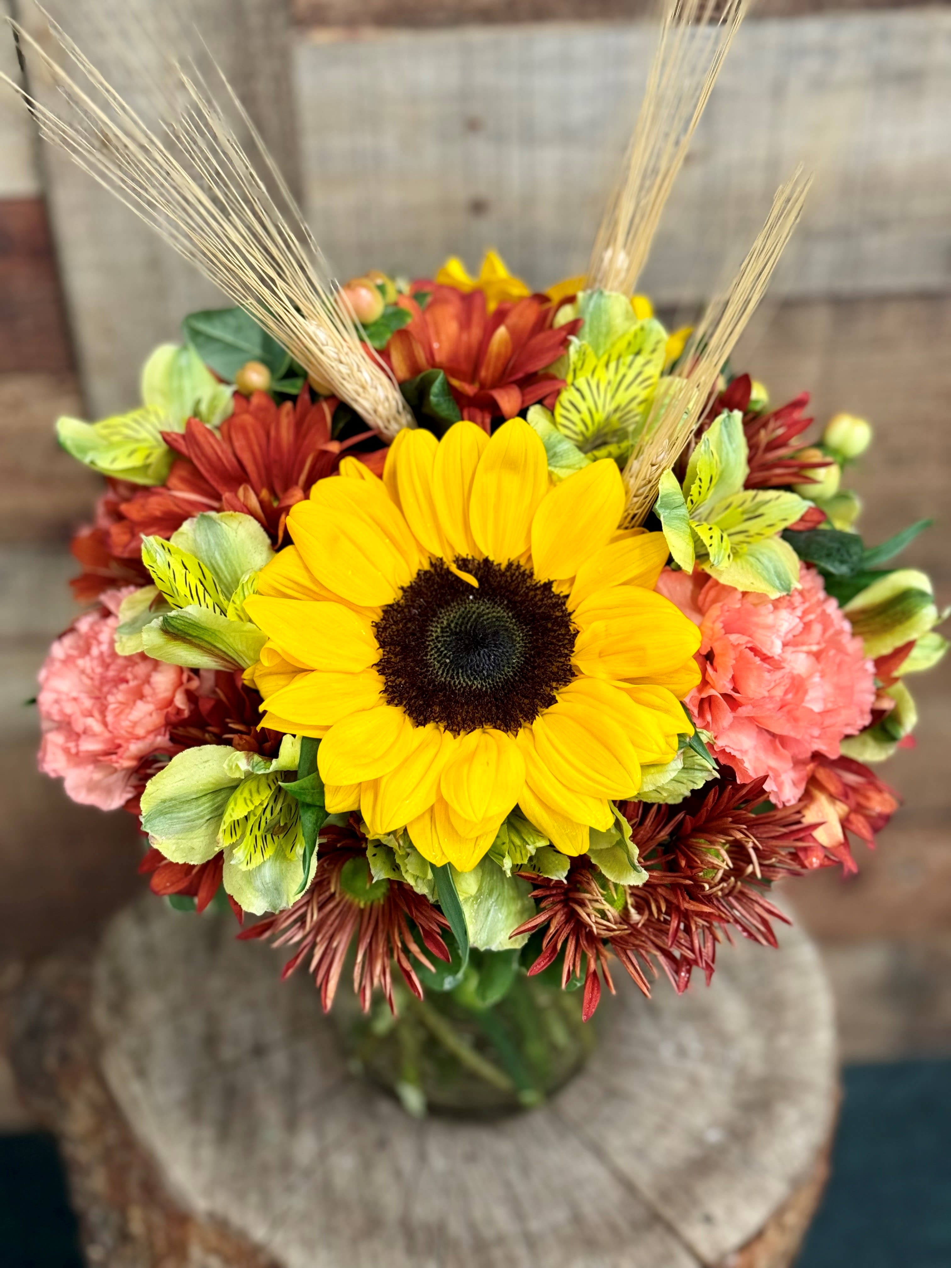 Autumn Splendor - Uplifting sunflowers paired with traditional autumn colors with a touch of wheat is a perfect addition to any table. 