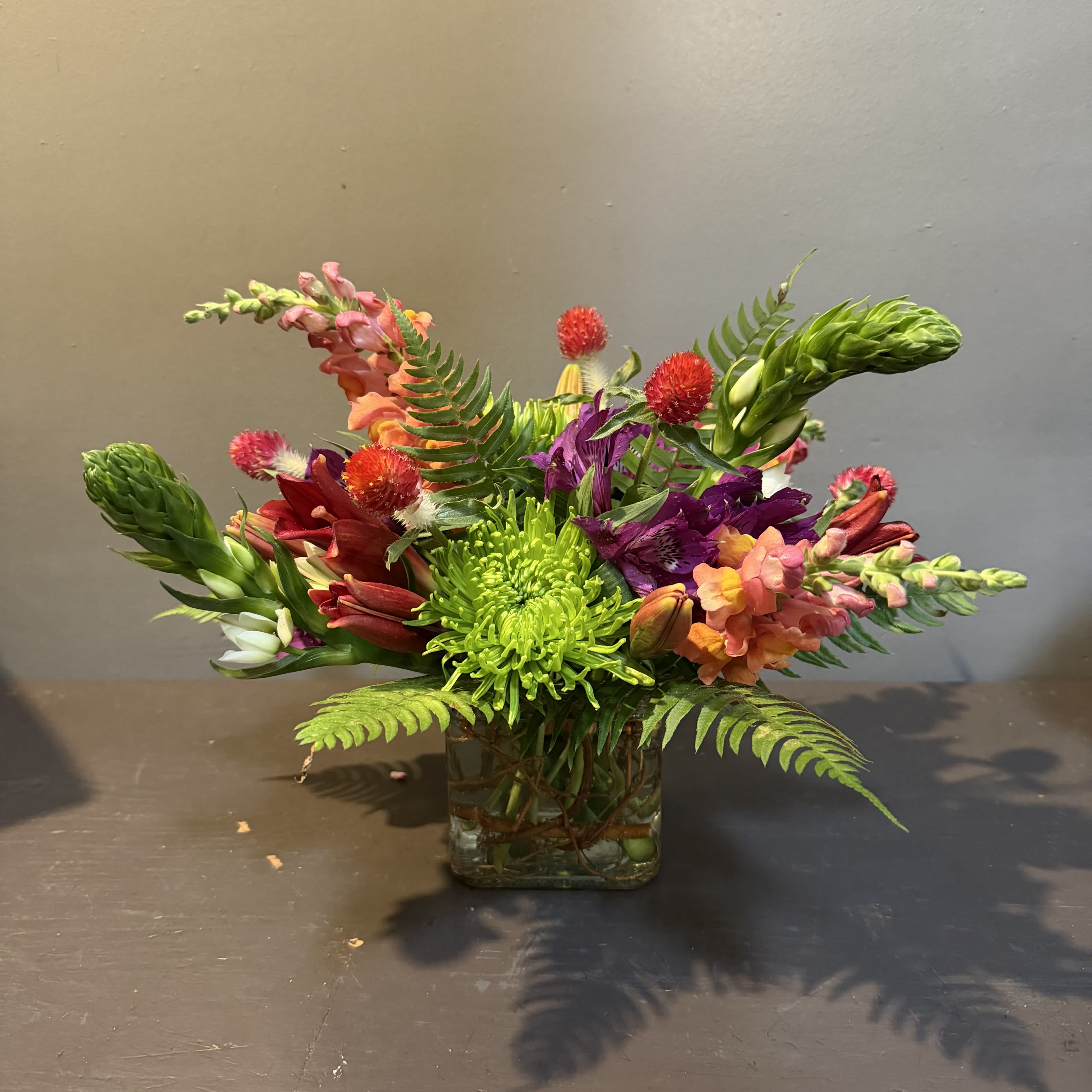 Colorful mixed bouquet in a square glass vase