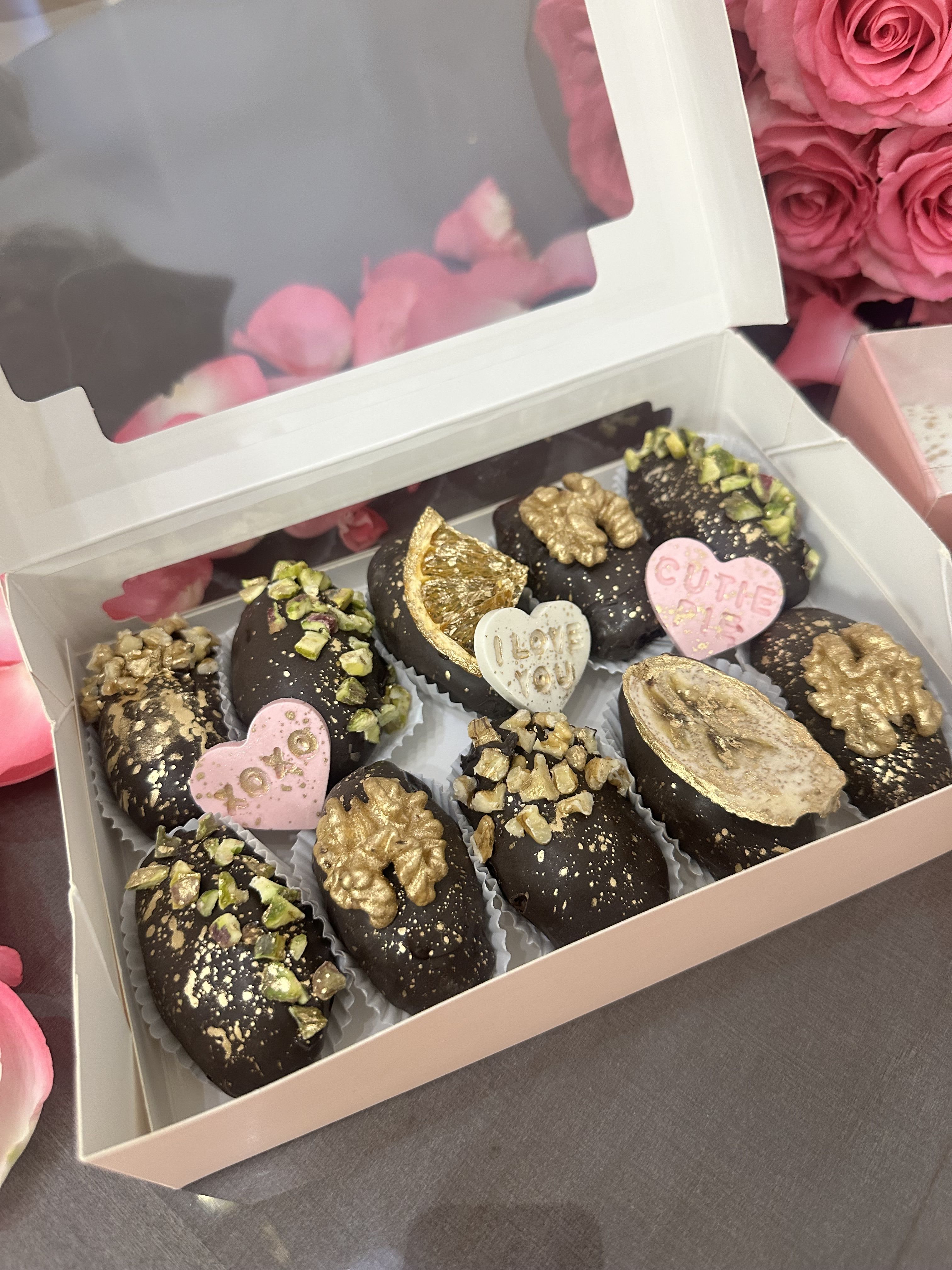 Box of chocolate-covered treats with pink heart decorations