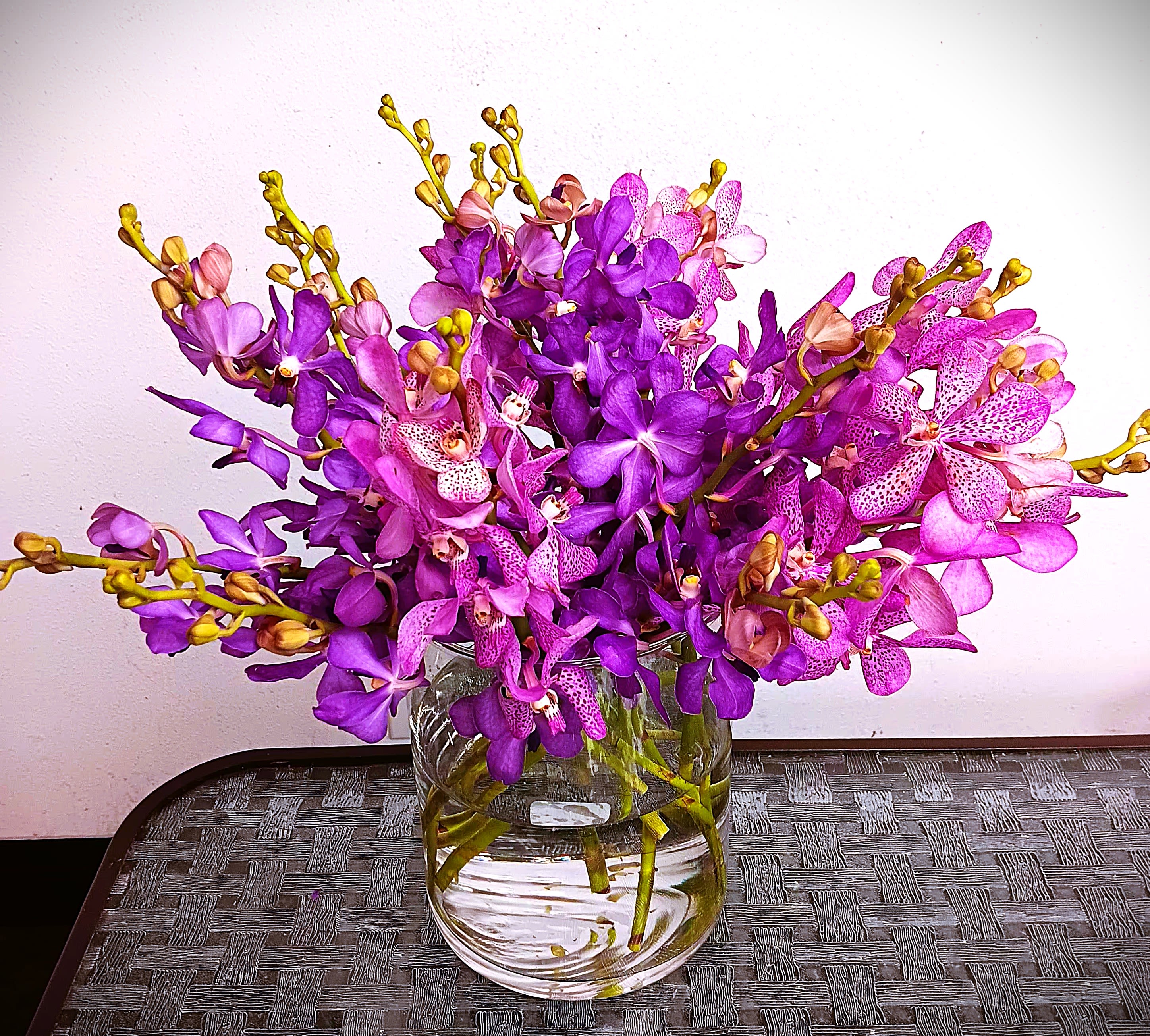 Purple orchids arranged in a clear glass vase
