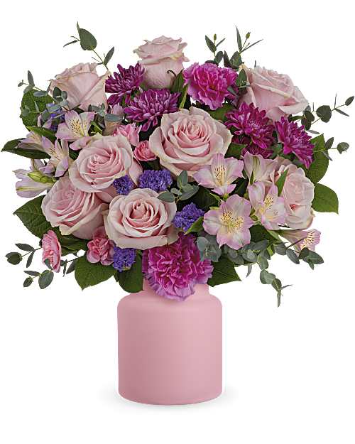 Pink roses and purple flowers arranged in a pink vase