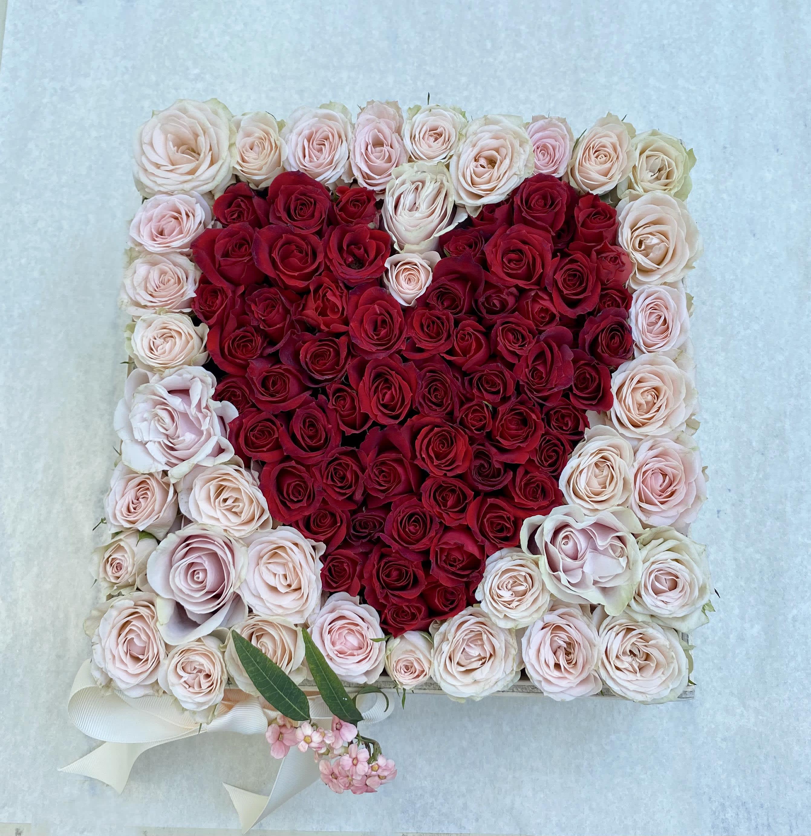 Heart-shaped rose arrangement in red and blush pink