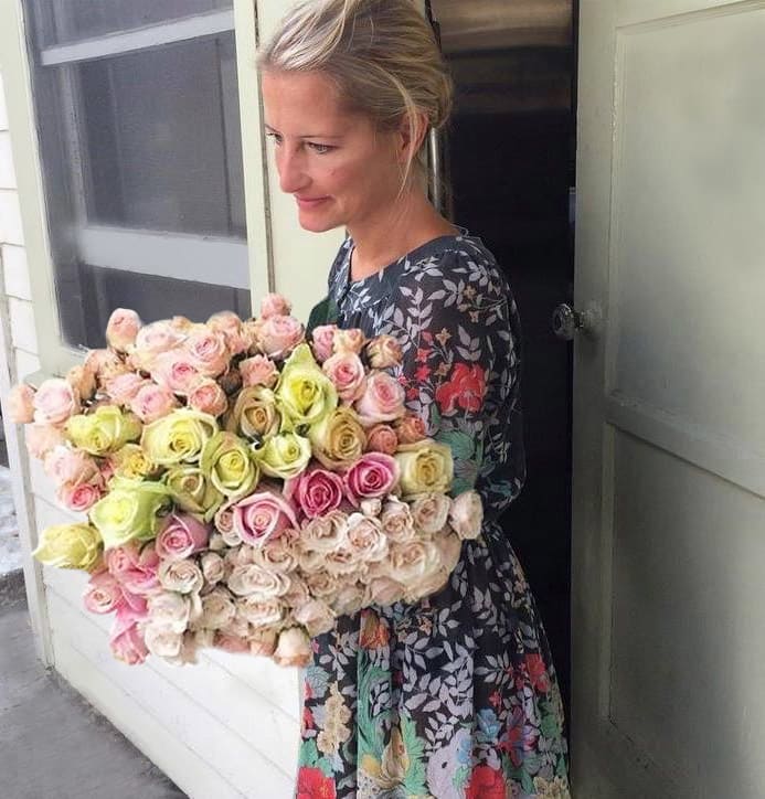 Woman holding a large bouquet of pastel roses