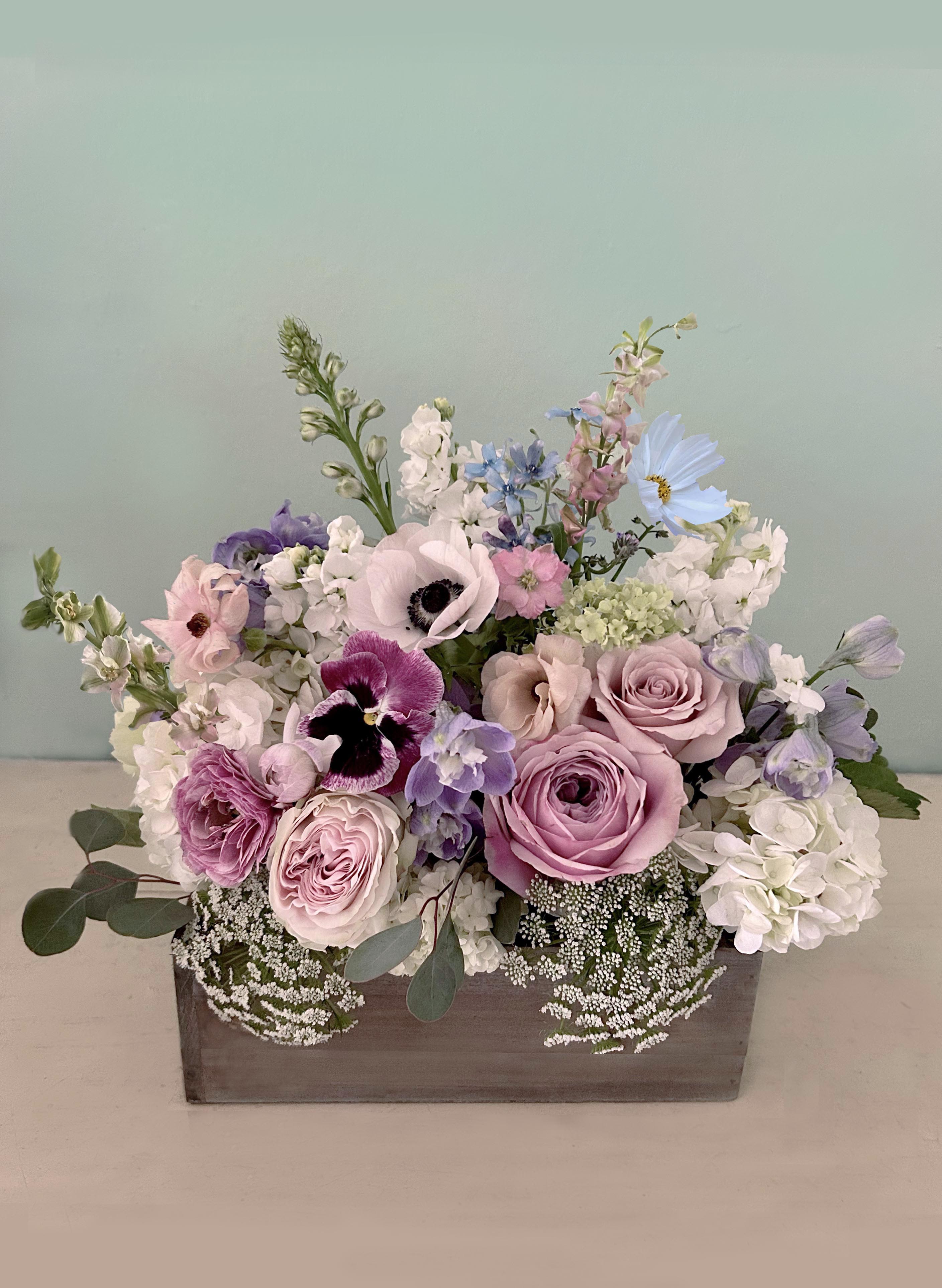 Fulham flower box - A gorgeous and natural, whimsical English garden style flower box full of pretty stems in muted and delicate pastels of blues, violets, dusty green, sand and white. So lovely as a gift or for yourself, cute in the kitchen or on the dinner table. Scents and pretty palettes to swoon upon. Ready for LA hand delivery by our own staff to guarantee a perfect journey from studio to recipient. The rectangular box measures appx 6" by 4" and is 5" tall, the arrangement is appx 11" tall 