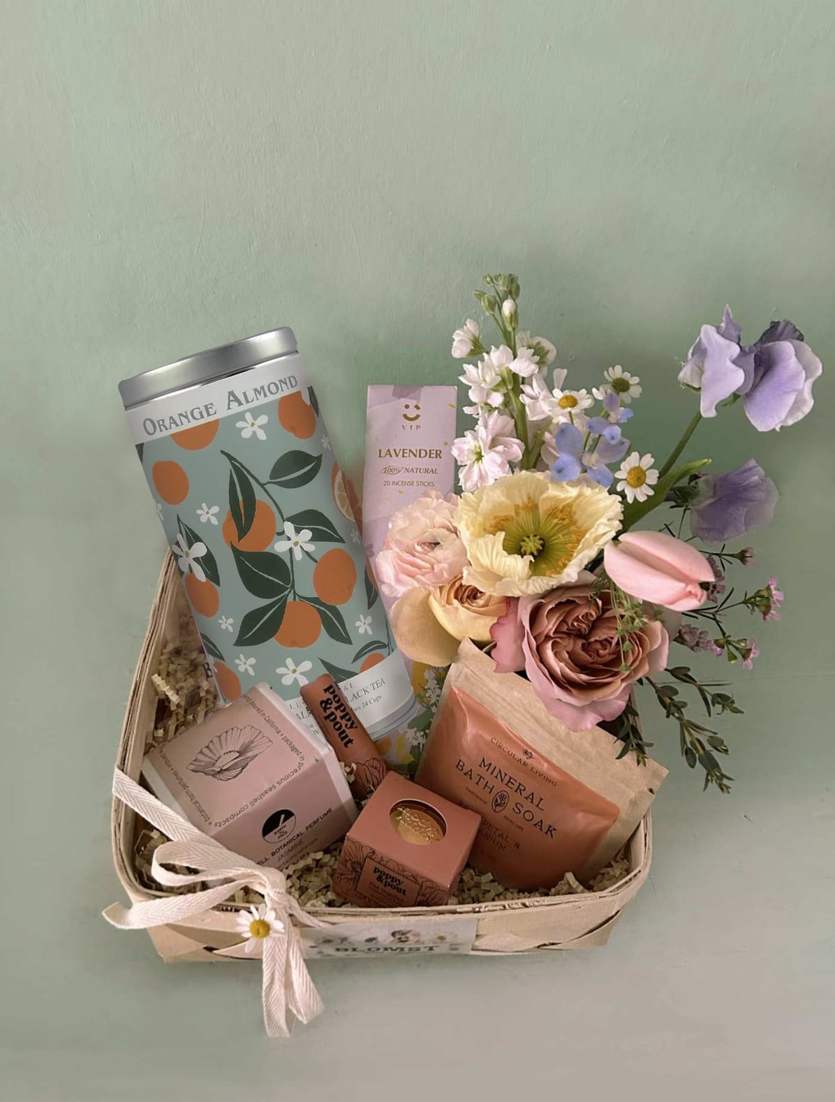 Gift basket with flowers, bath items, and a ribbon bow