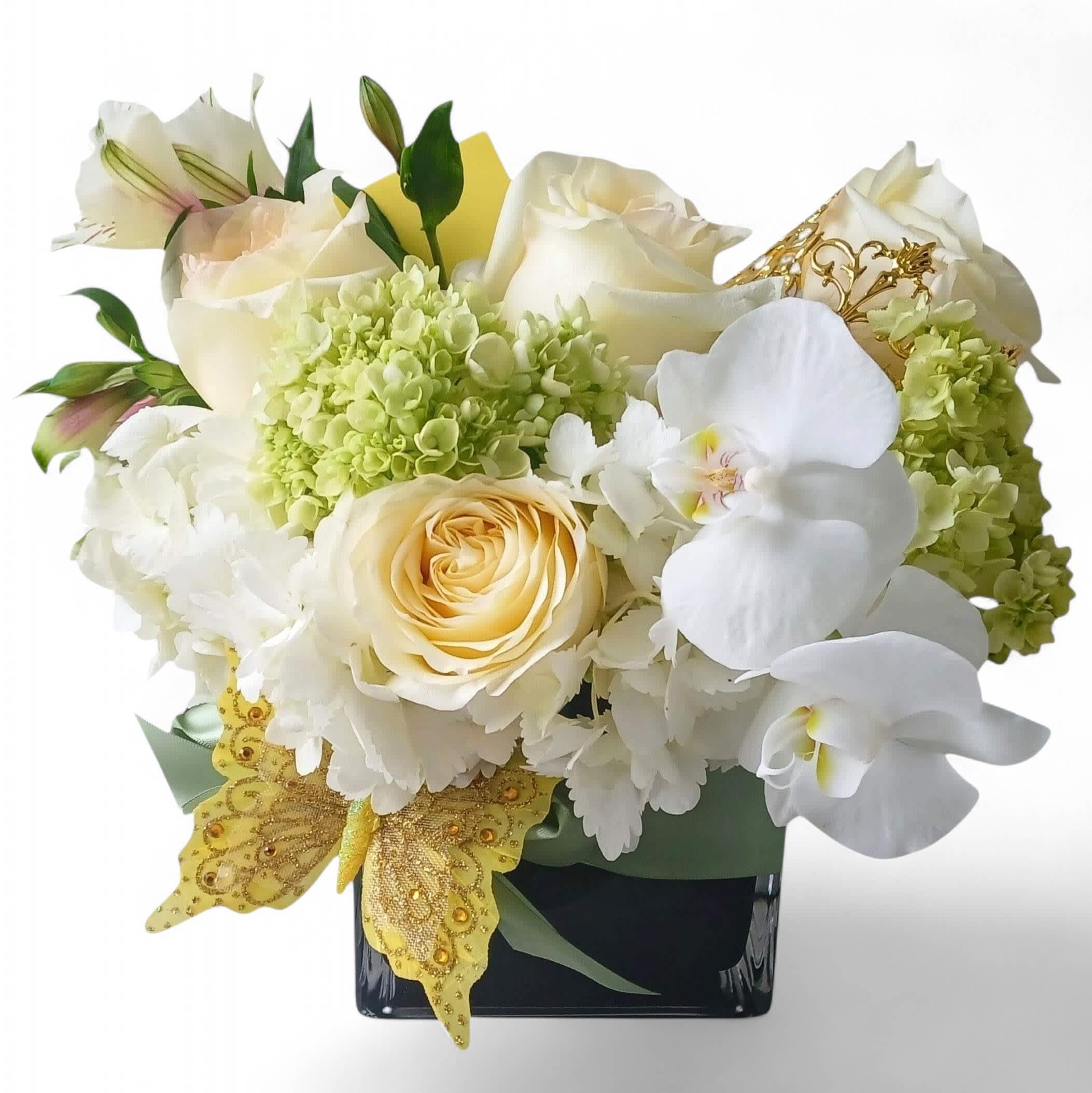White roses, orchids, and hydrangeas in a black vase with gold butterfly accents