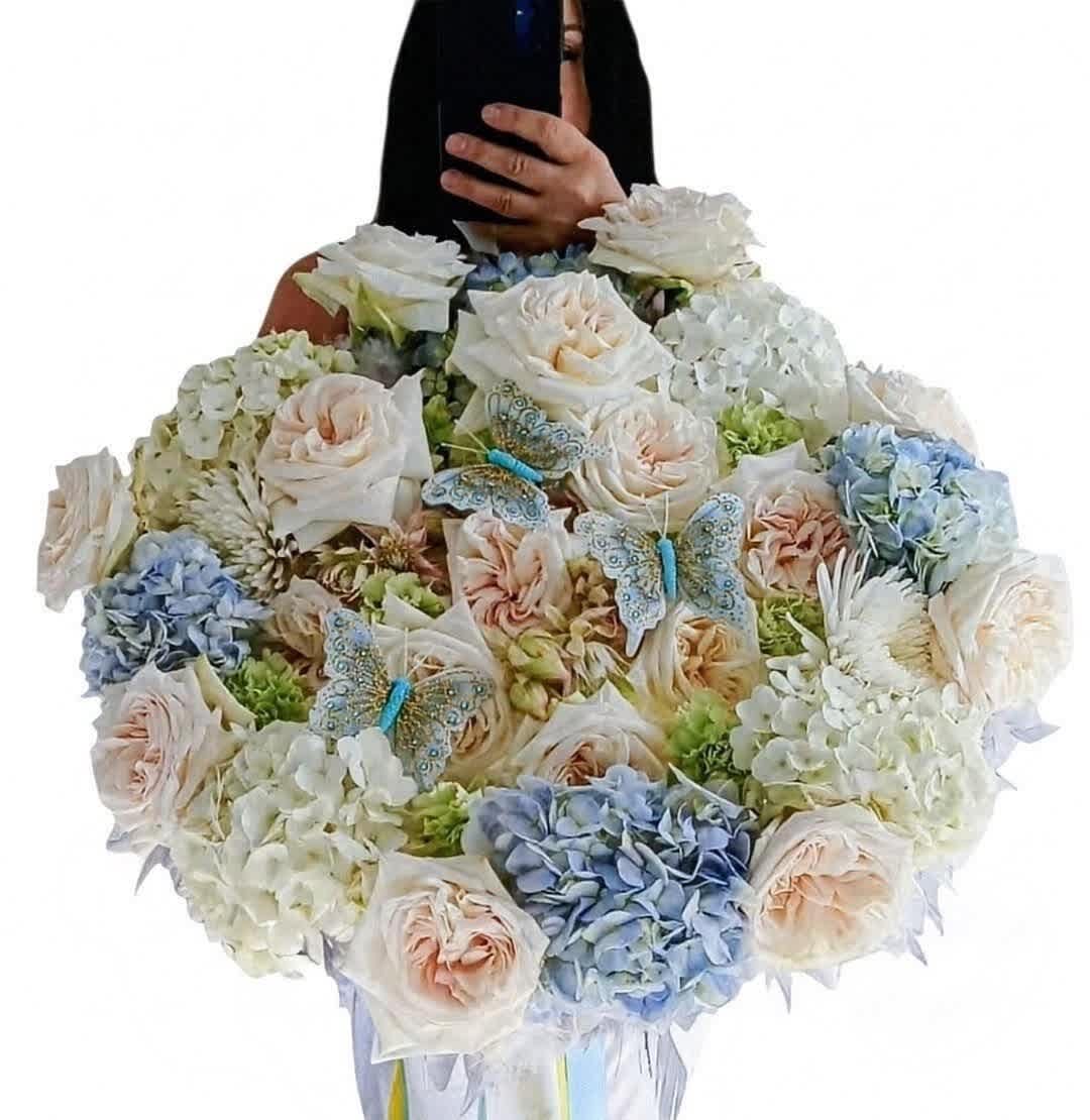 Large bouquet of pale roses and hydrangeas with butterfly decorations