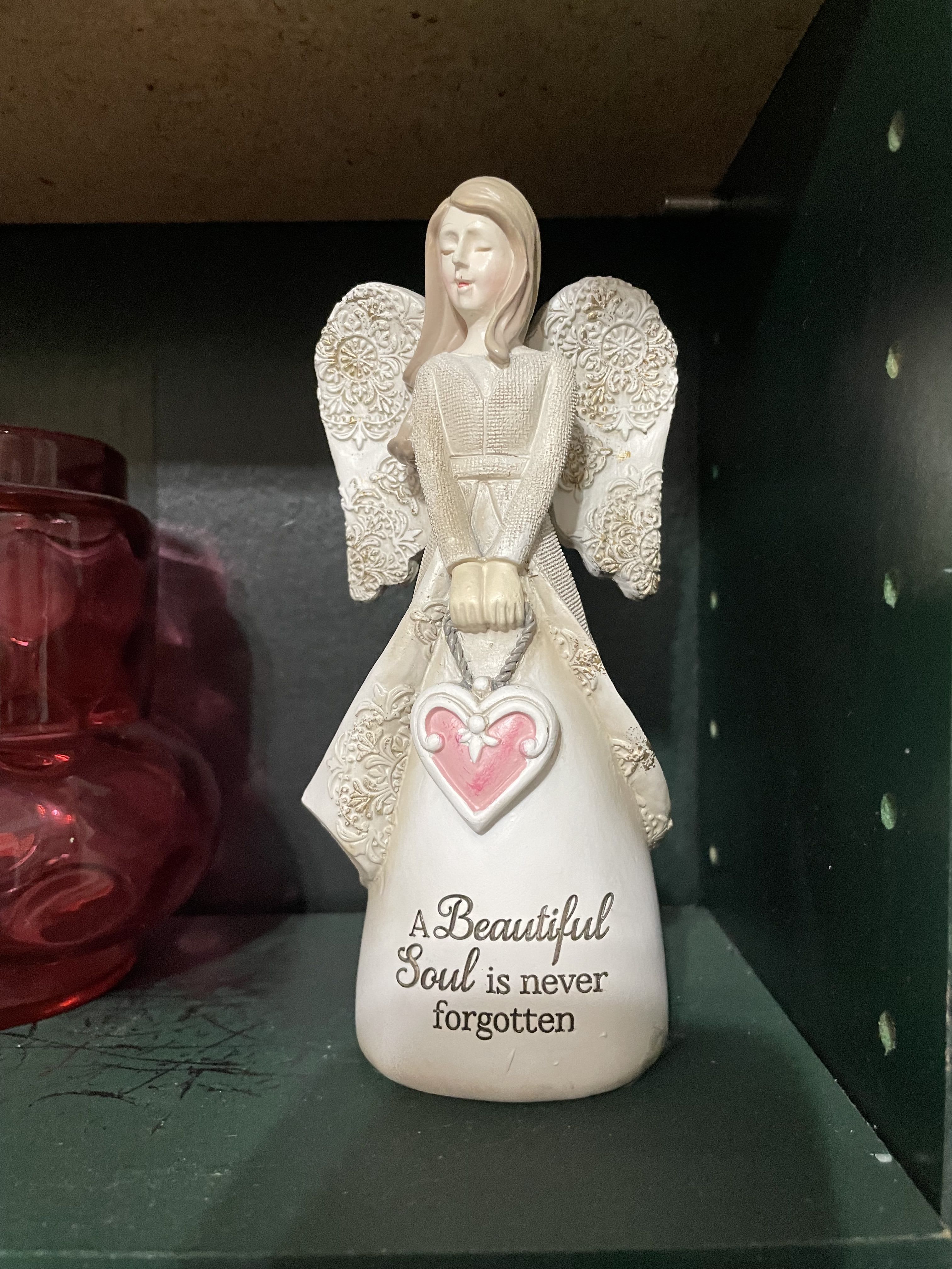 Decorative angel figurine with a pink heart and memorial text