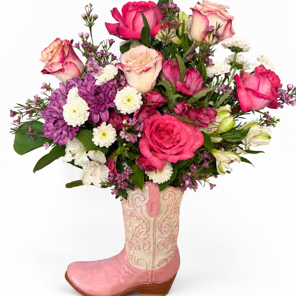 Mixed pink and white flower arrangement in a pink cowboy boot vase