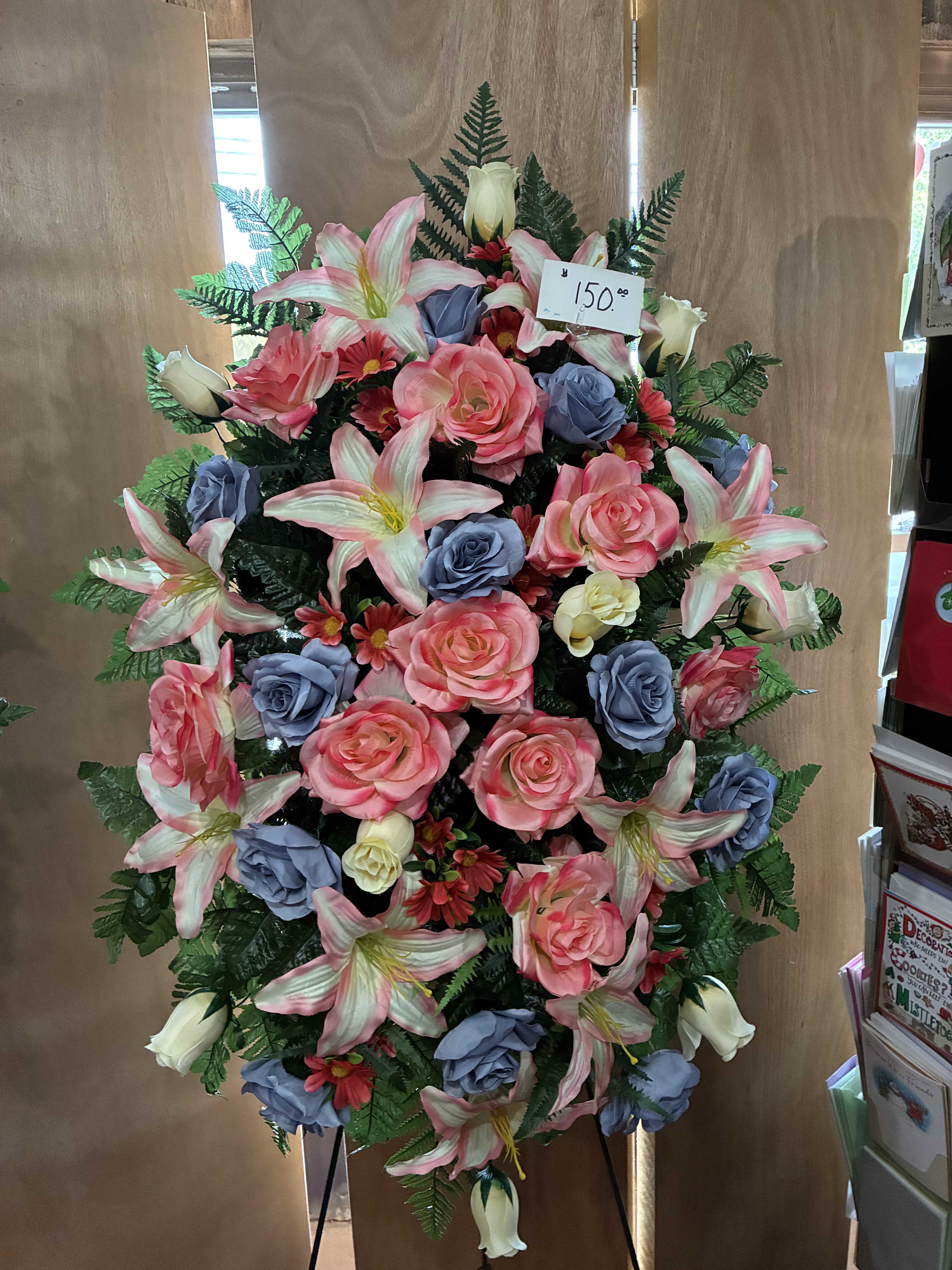 Large standing floral spray with pink lilies, roses, and blue roses