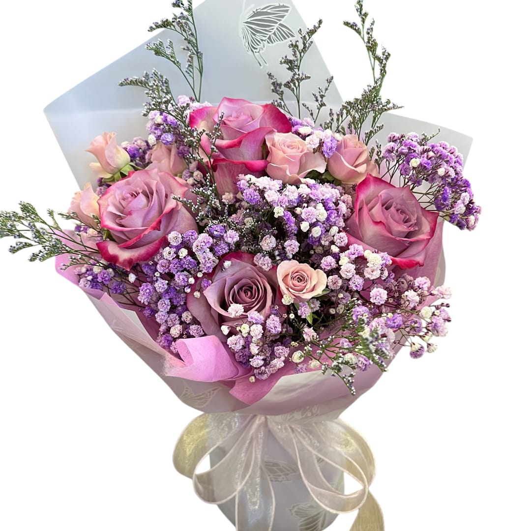 Pink and lavender rose bouquet wrapped in pastel paper with a ribbon