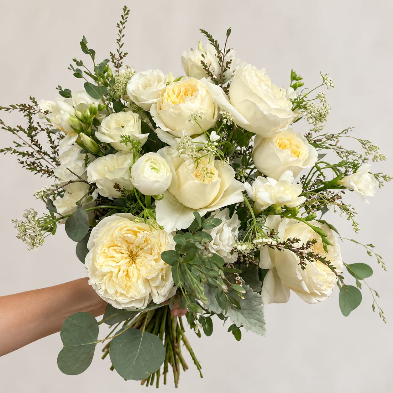 White and cream bridal bouquet with roses and mixed greenery