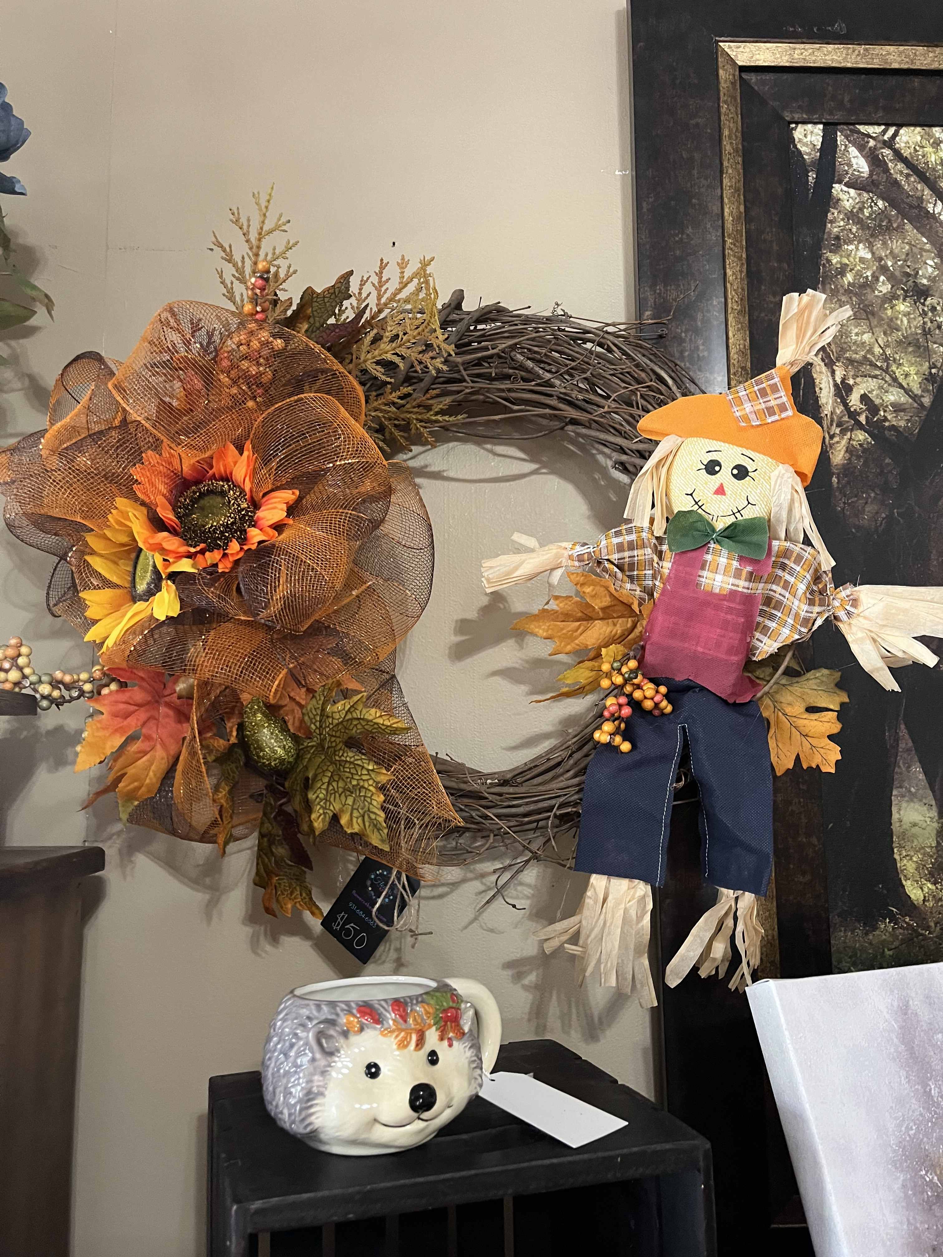 Fall wreath with sunflowers and a scarecrow decoration on a wall