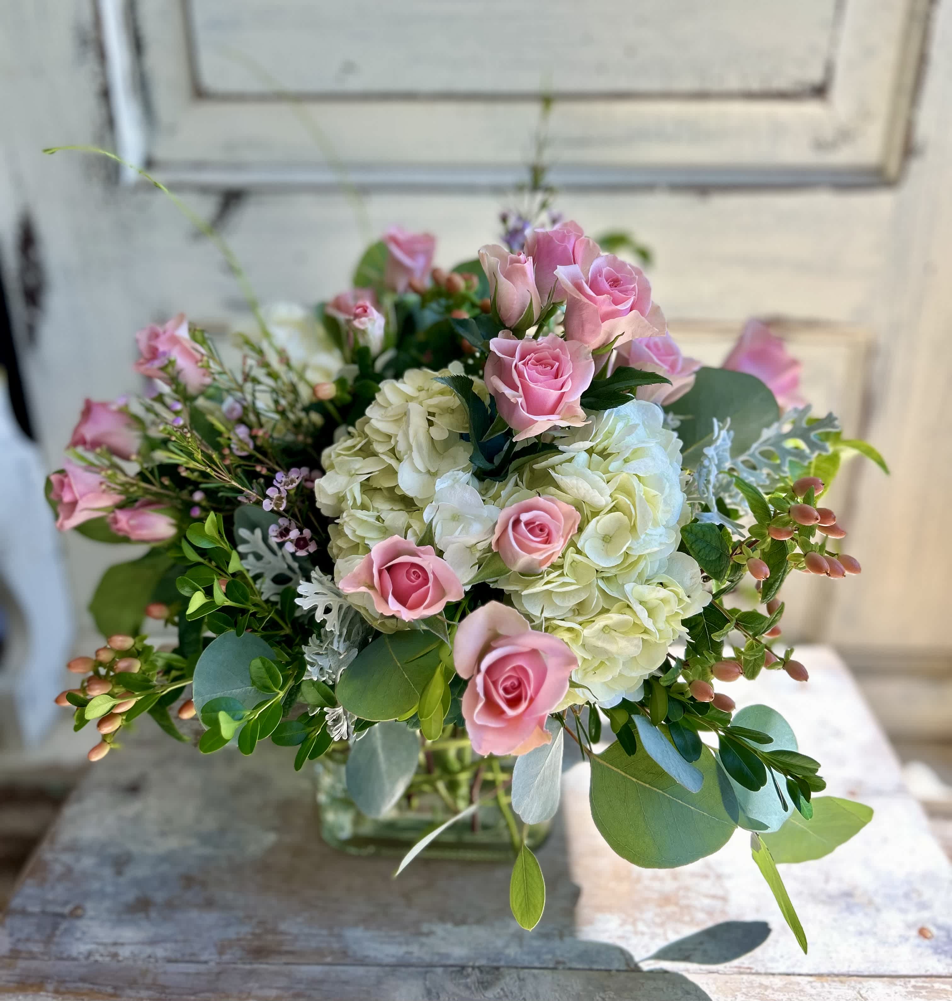 Pink roses and white hydrangeas in a clear glass vase