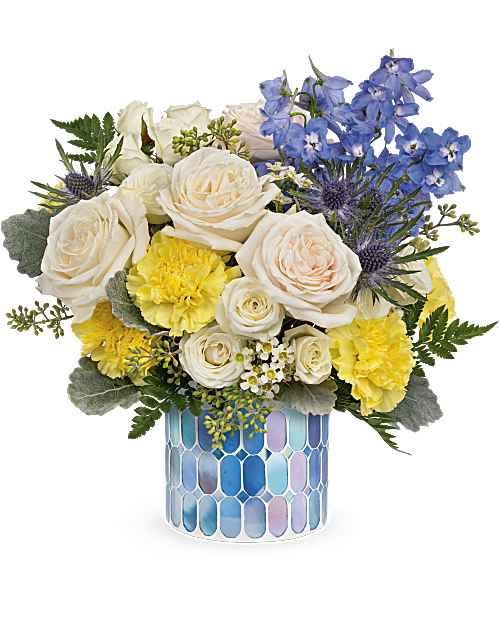 Loving Wishes for Mom - Like wispy clouds in a bright blue sky, this beautiful bouquet of white and blue flowers in a stained glass mosaic vase is a refreshing gift for any occasion. This breathtaking bouquet includes white spray roses, light blue delphinium, blue eryngium, white waxflower, yellow carnations, seeded eucalyptus, dusty miller and leatherleaf fern. Delivered in Teleflora's Blue Beauty Mosaic. Orientation: All-Around