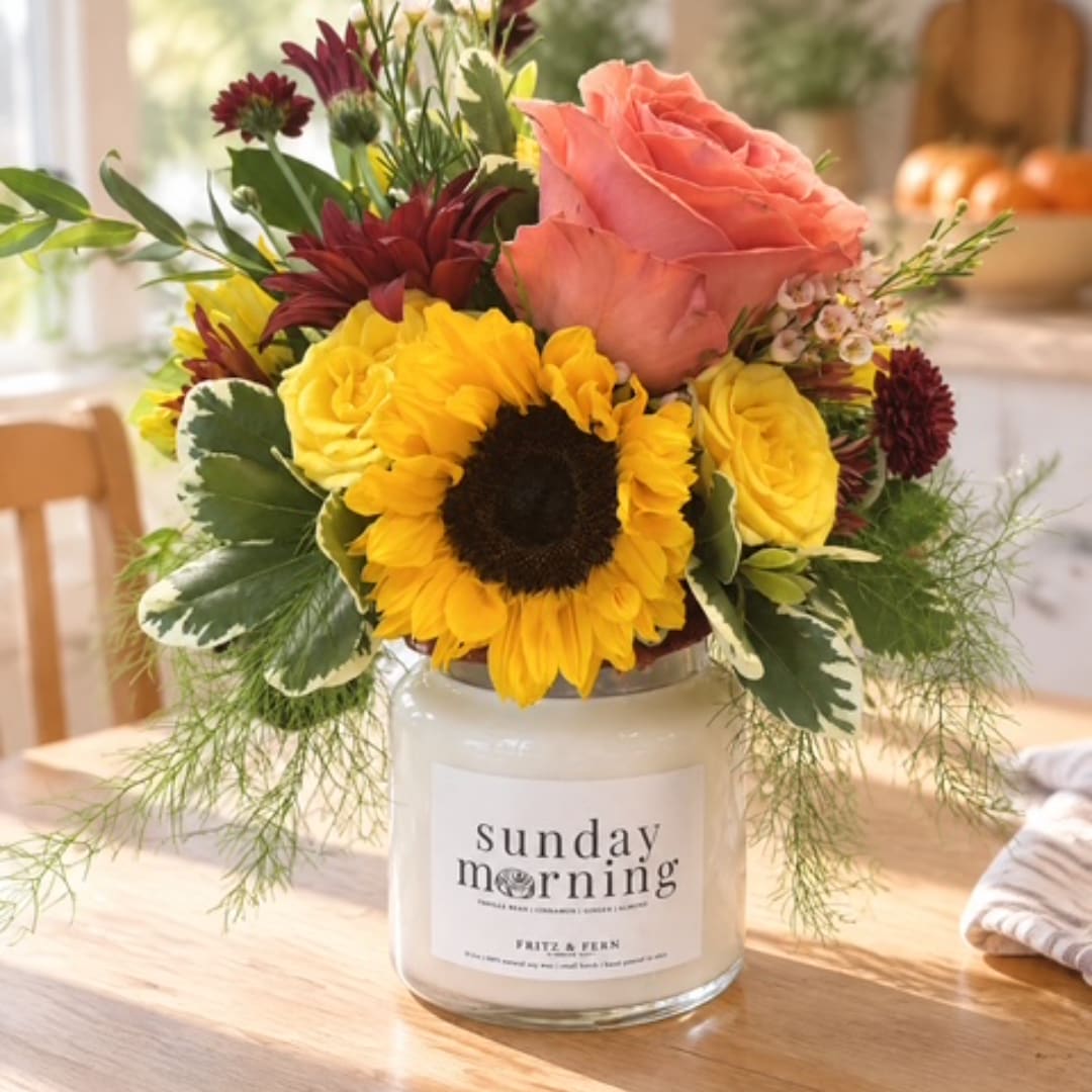 Mixed bouquet in a glass candle jar with a sunflower and pink rose