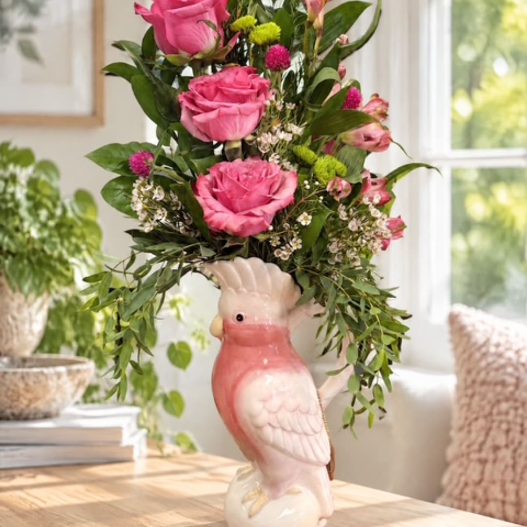 Pink roses arranged in a bird-shaped ceramic vase